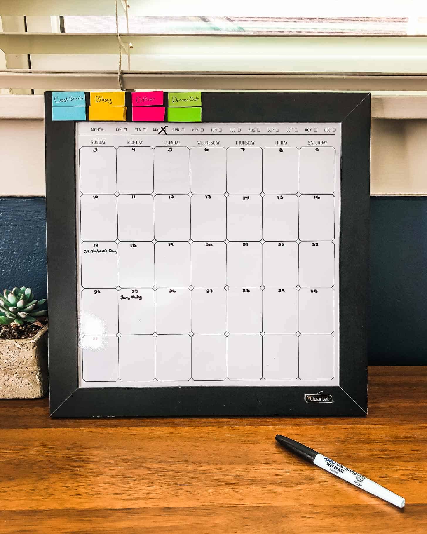 a dry erase calendar on a wooden table