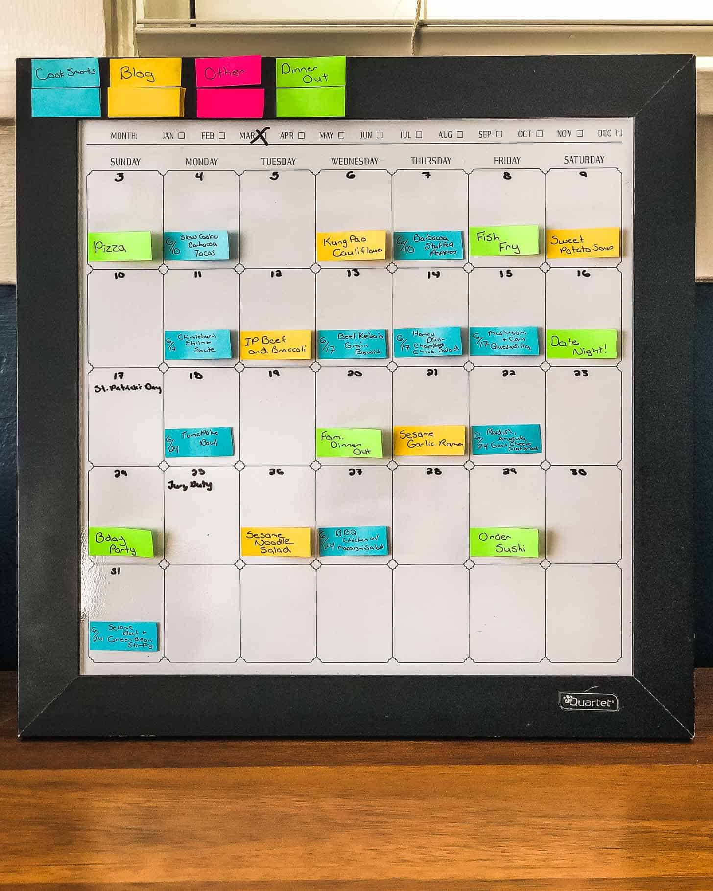 a dry erase calendar with colored paper strips