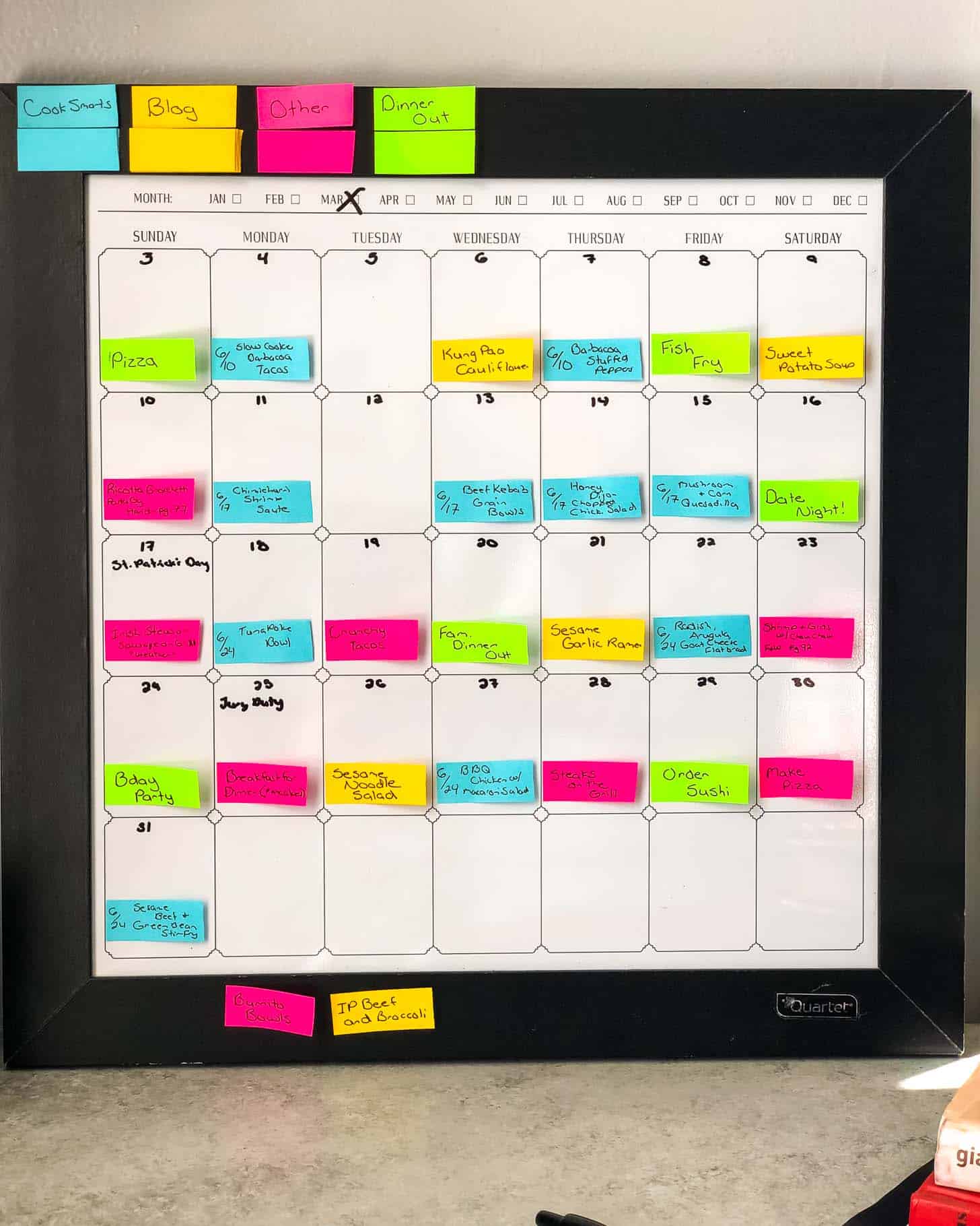 a dry erase calendar with colored paper strips