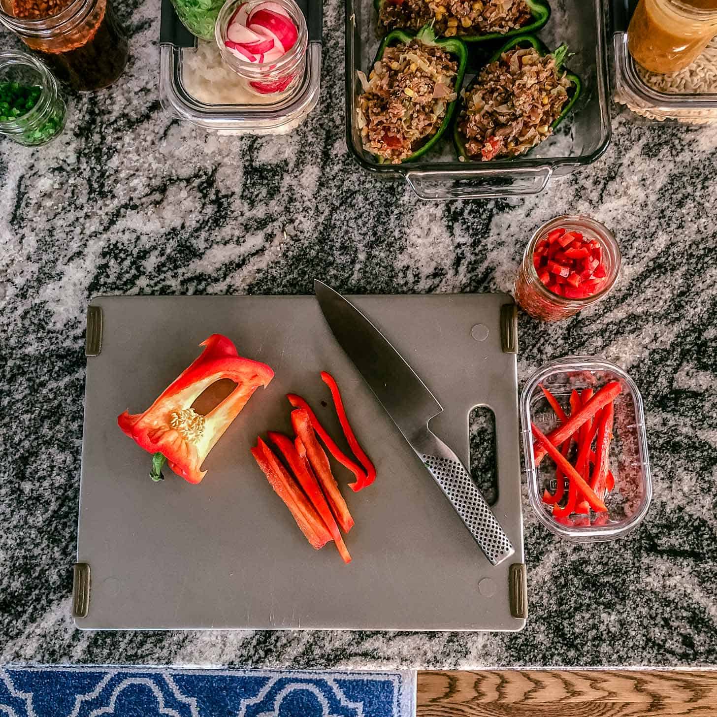 a cutting board with a knife and a red pepper