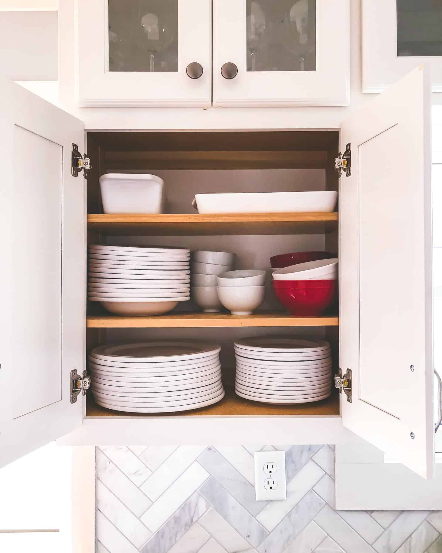 an open cabinet with plates and bowls