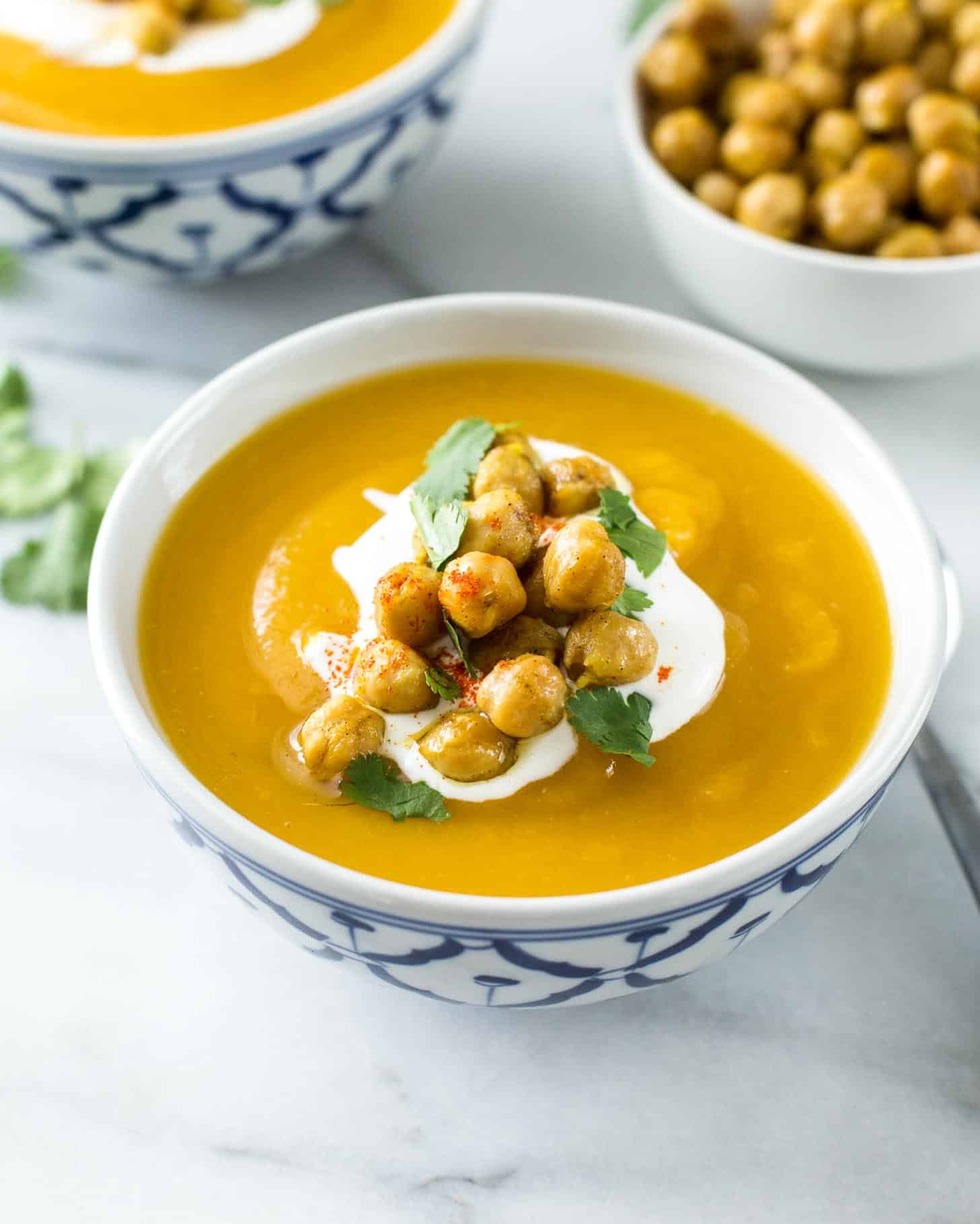a bowl of Sweet Potato Soup topped with sour cream and chickpeas