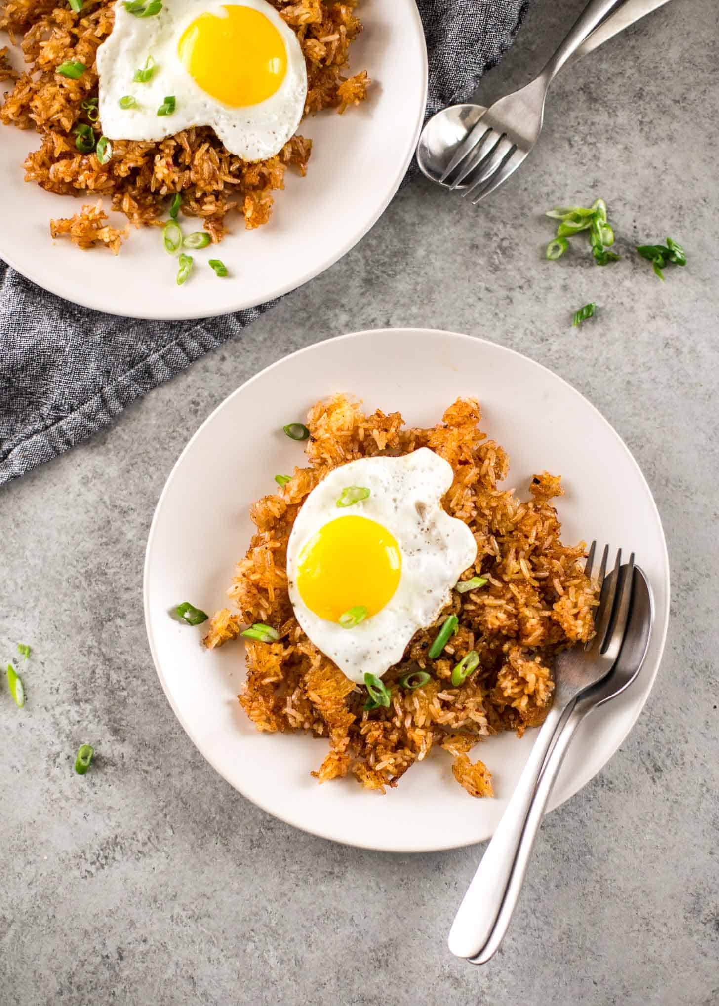 Thai Crispy Rice topped with a fried egg on a white plate