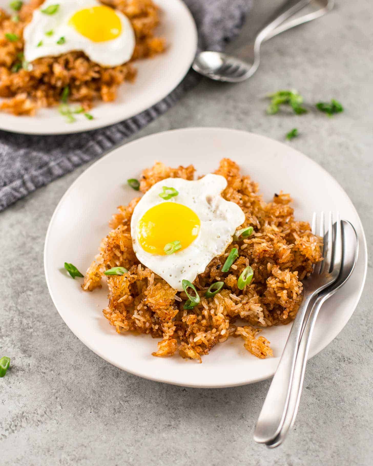 overhead image of Rice topped with a fried egg in a white bowl