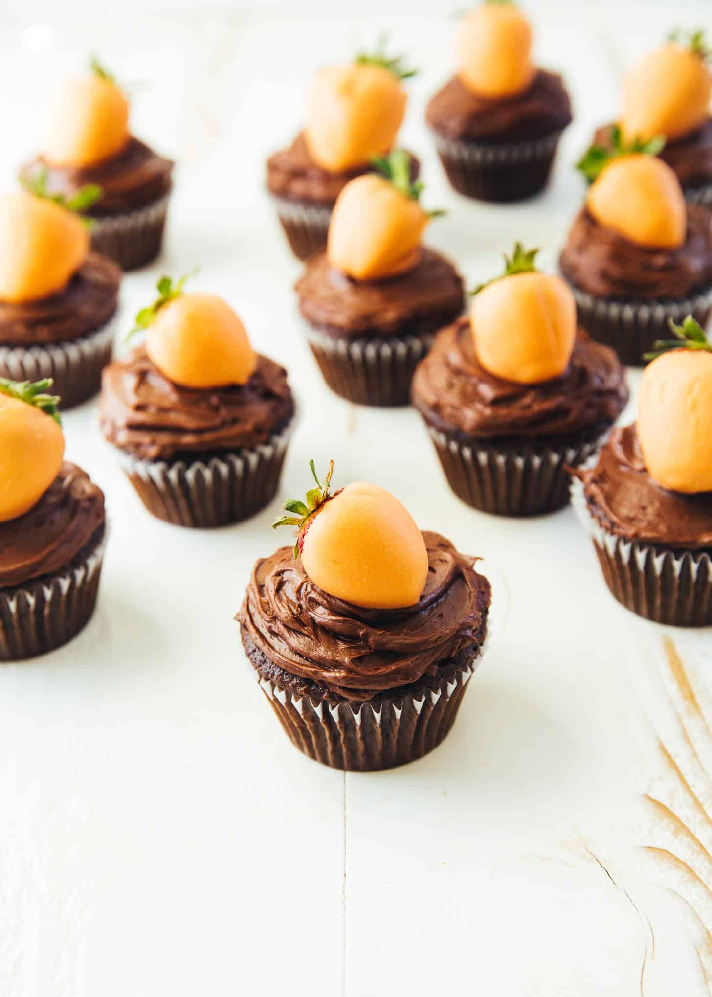 chocolate cupcakes topped with orange dipped strawberries