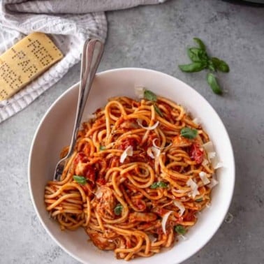 image of white bowl with chicken spaghetti and an instant pot in the background