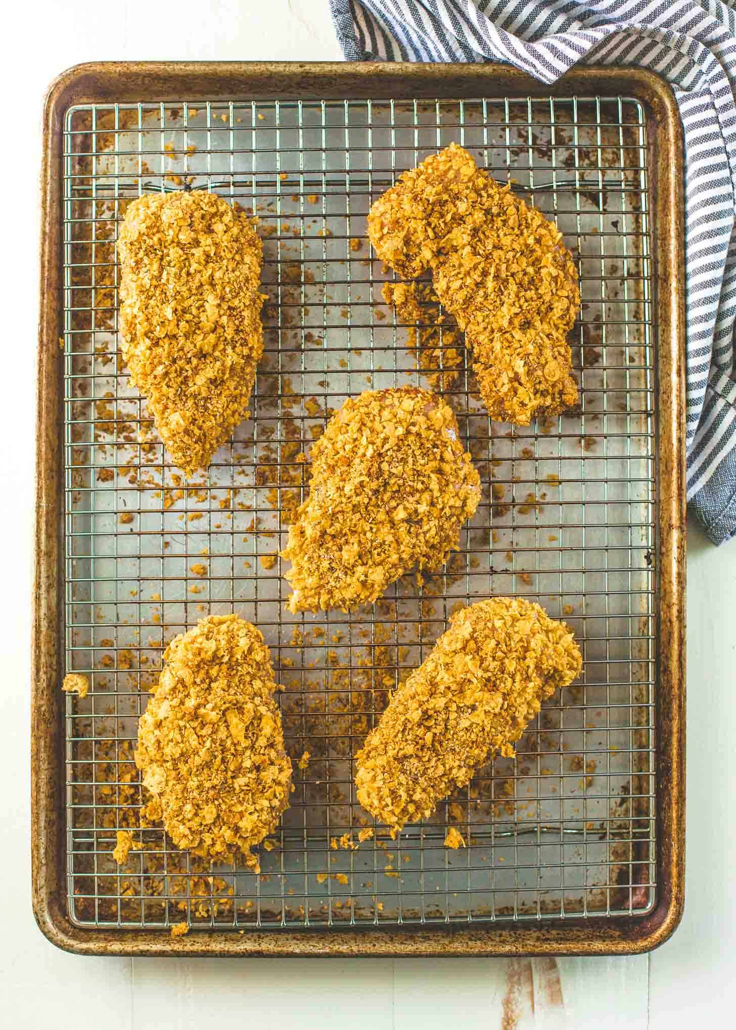 overhead image of cornflake chicken on a wire rack on a sheet pan
