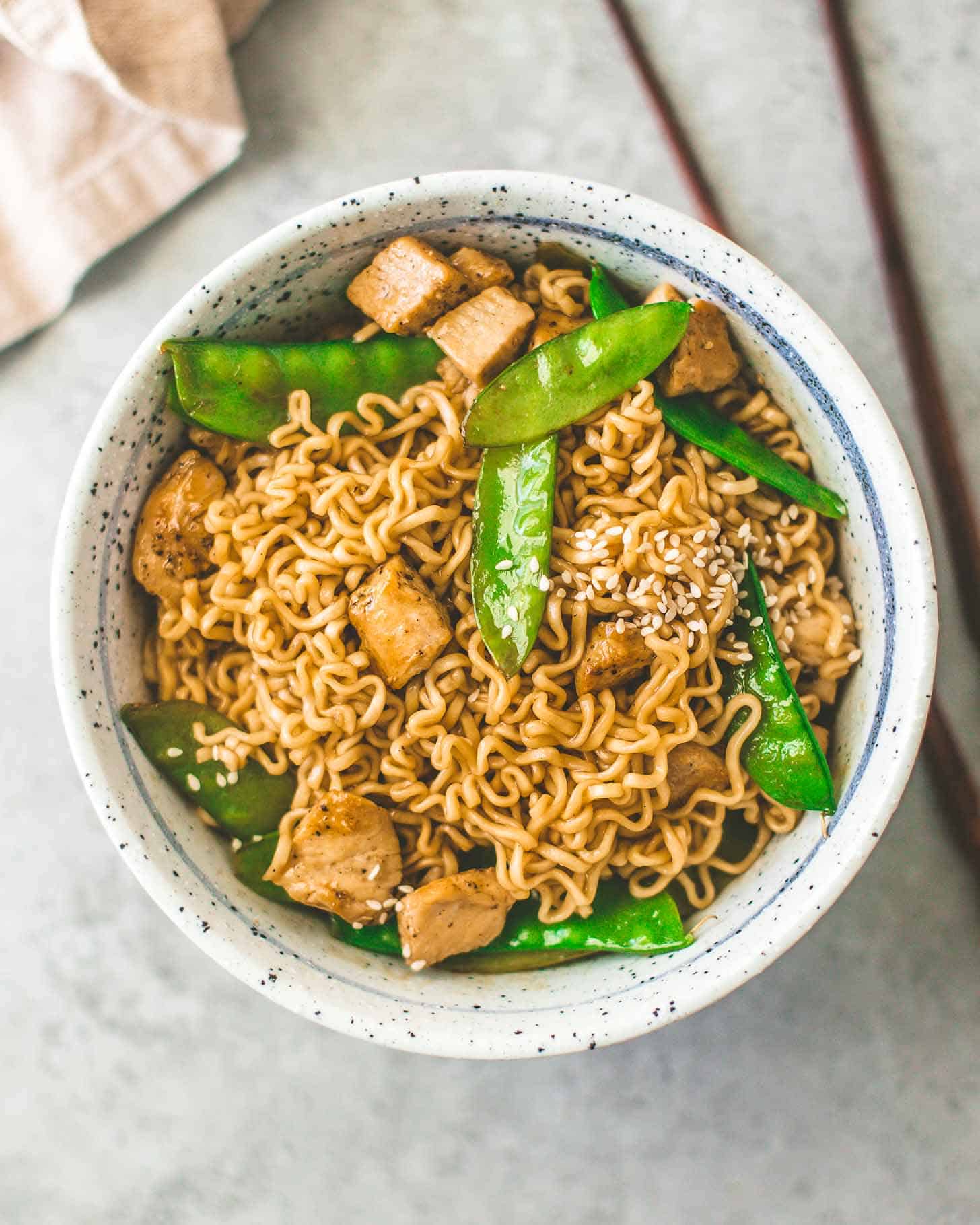 overhead image of Sesame Garlic Ramen Stir-Fry in a speckled bowl