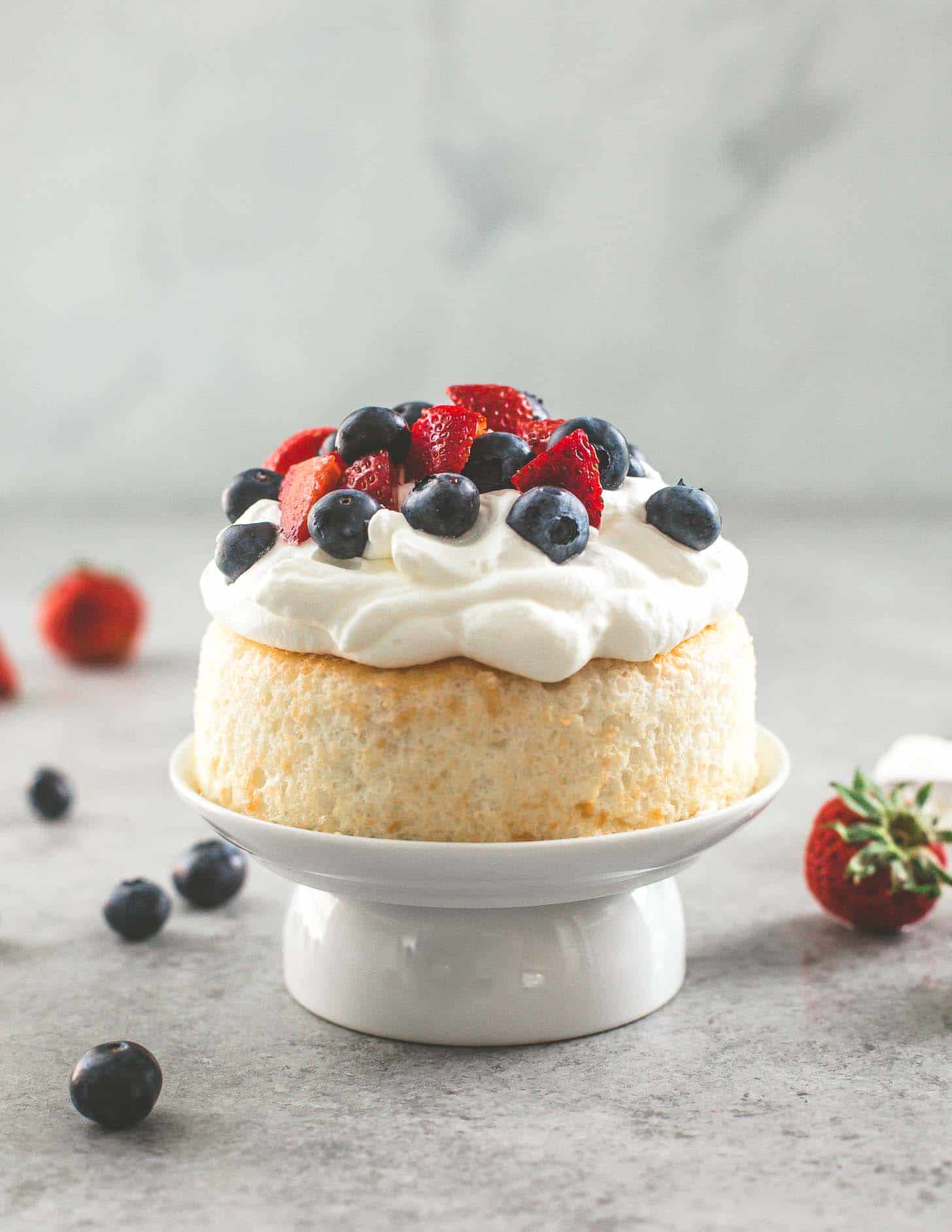 smash cake topped with whipped cream and berries