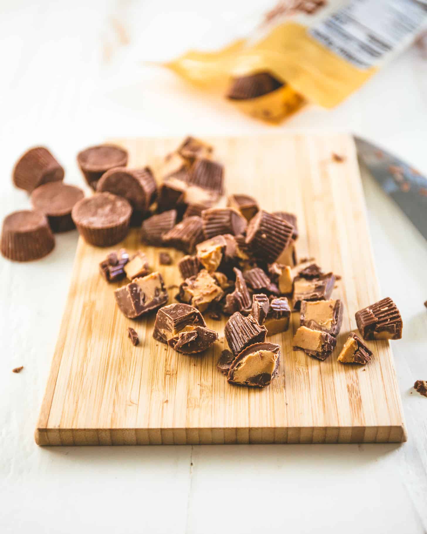 chopped pieces of Peanut Butter Cups on a wooden board