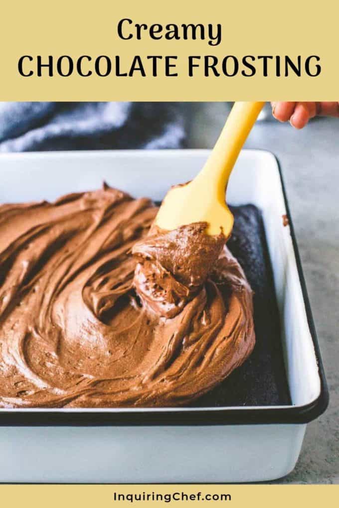Spatula spreading Creamy Chocolate Frosting on a chocolate cake