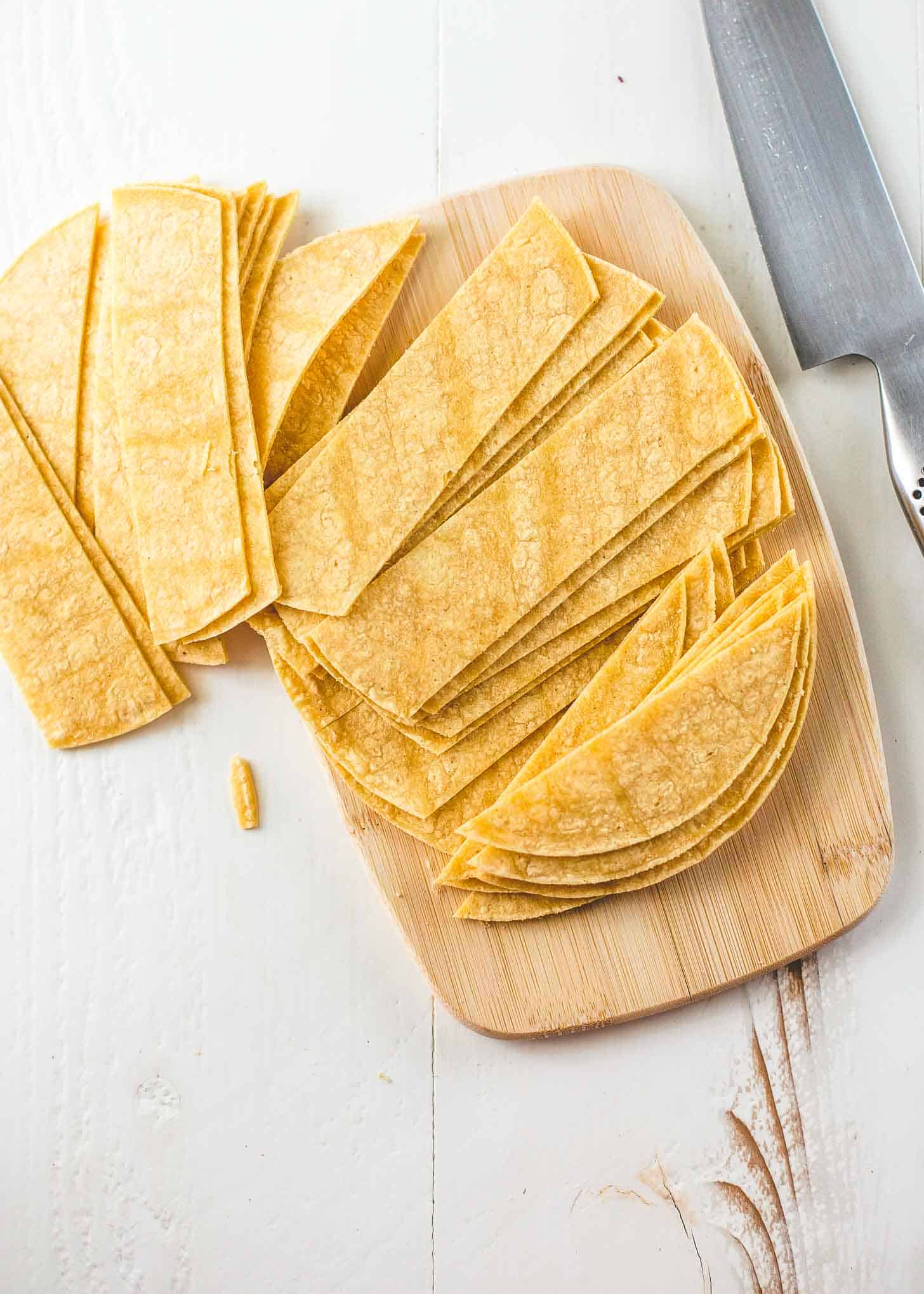 overhead image of corn tortillas sliced on a cutting board