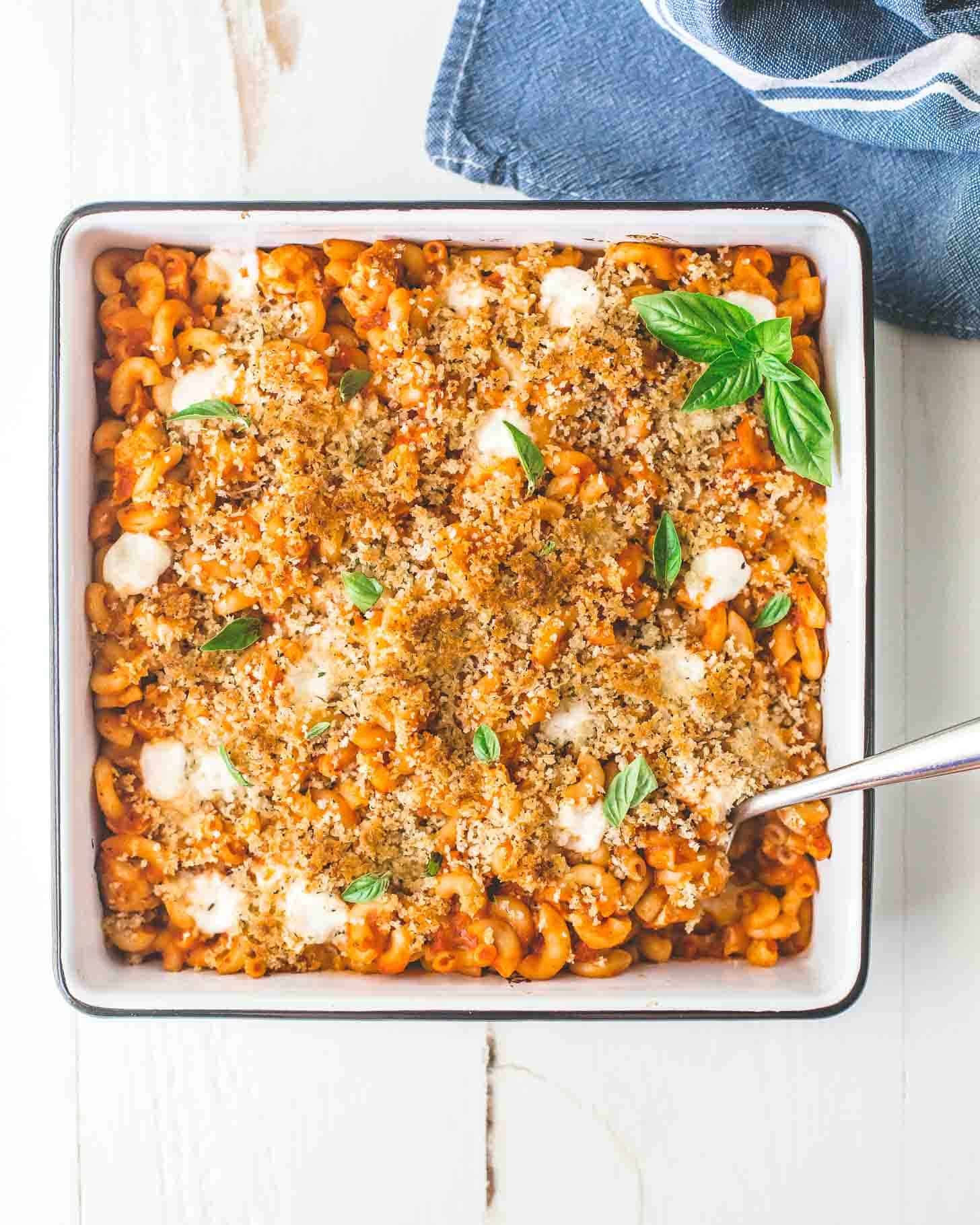 overhead image of Chicken Parmesan Pasta Bake in a square white baking dish