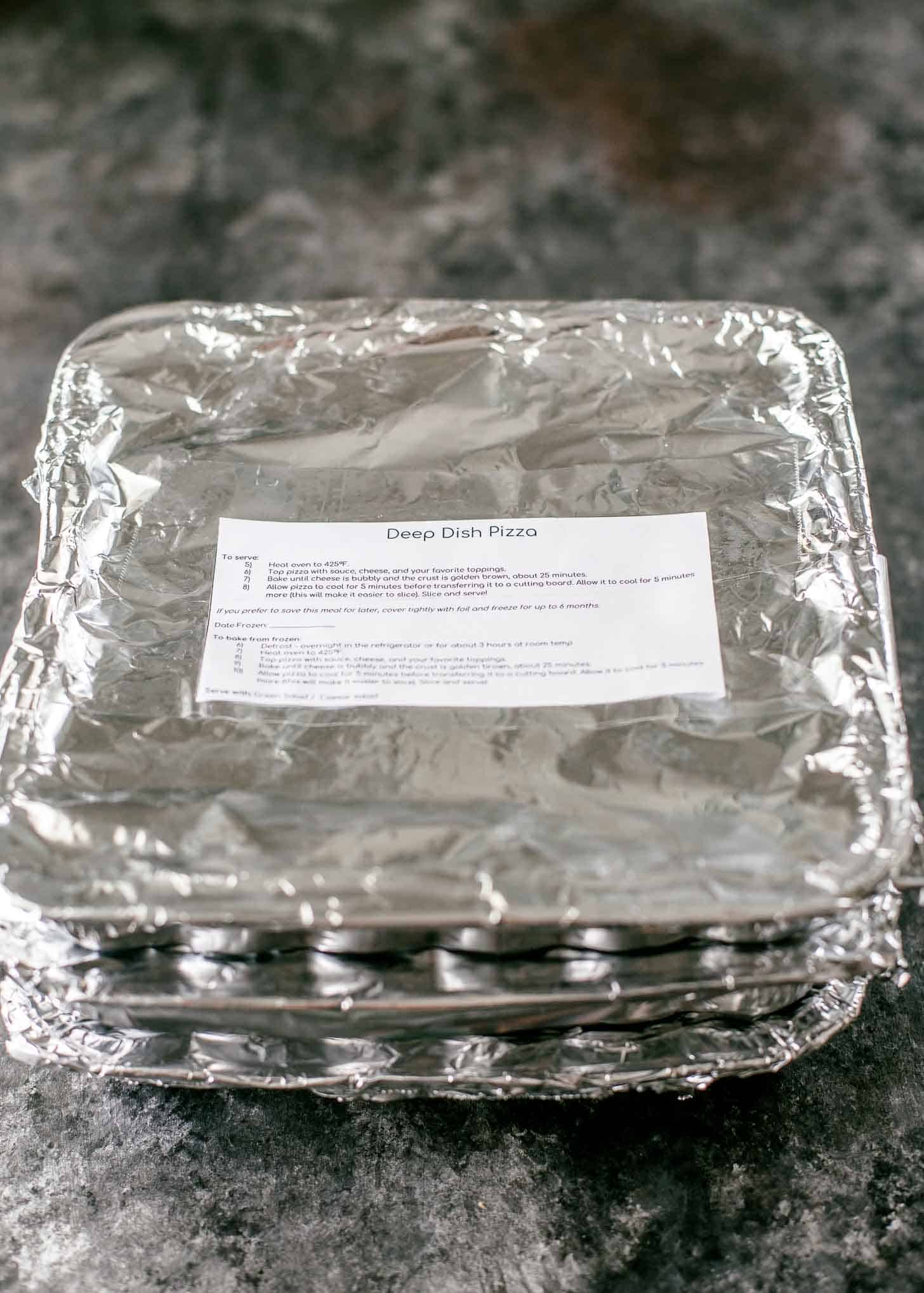 Deep Dish Pizza, wrapped in foil, with a freezer label