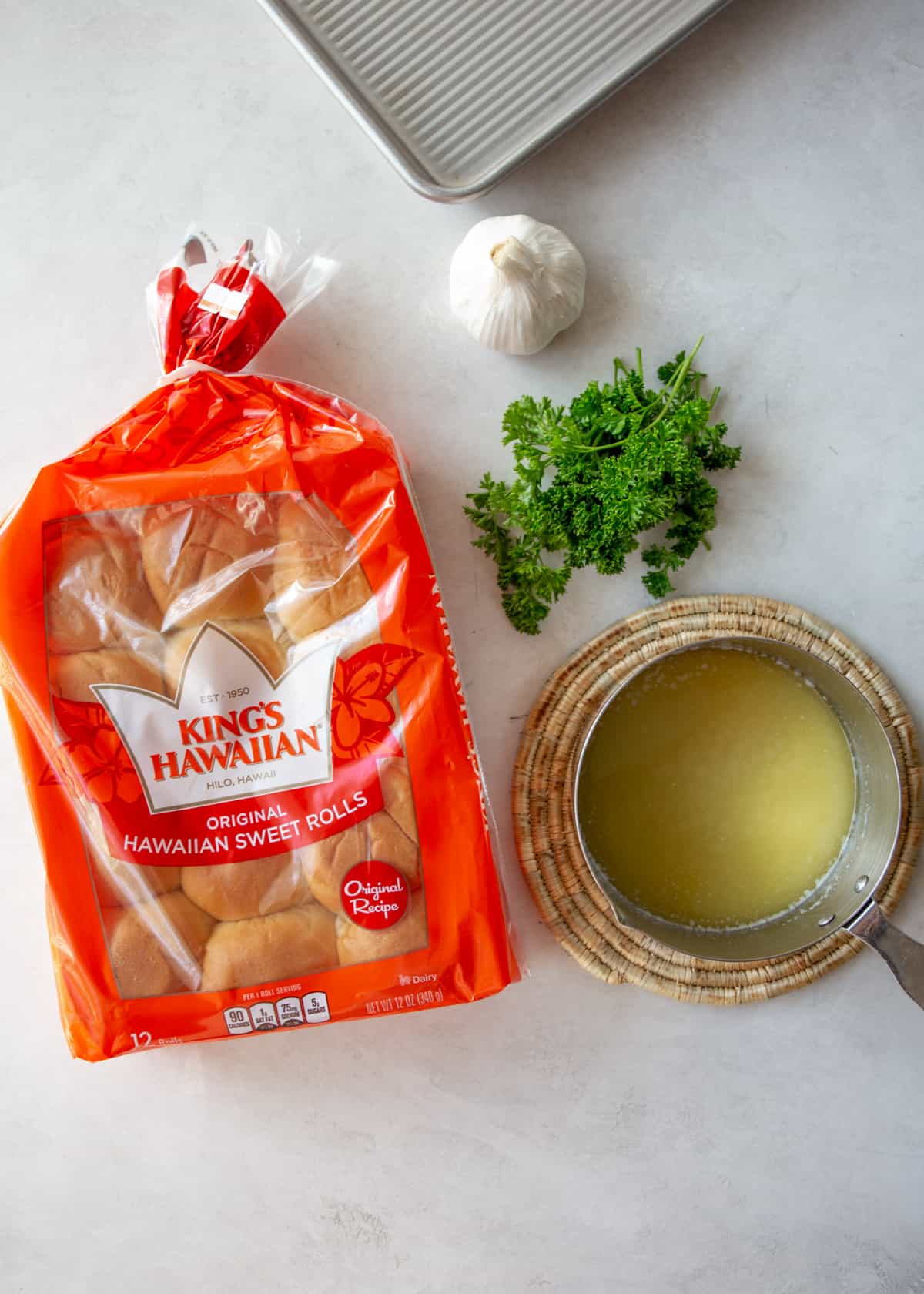 ingredients for making garlic bread hawaiian rolls on a grey countertop