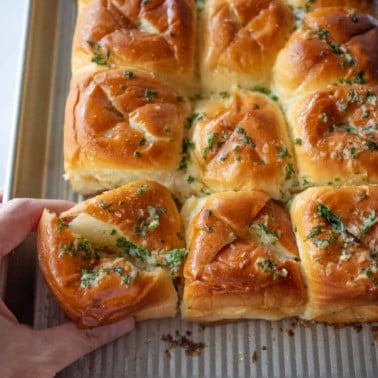 square image of garlic bread hawaiian rolls on a sheet pan