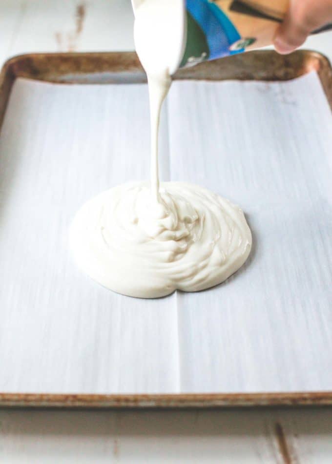 pouring yogurt on a sheet pan