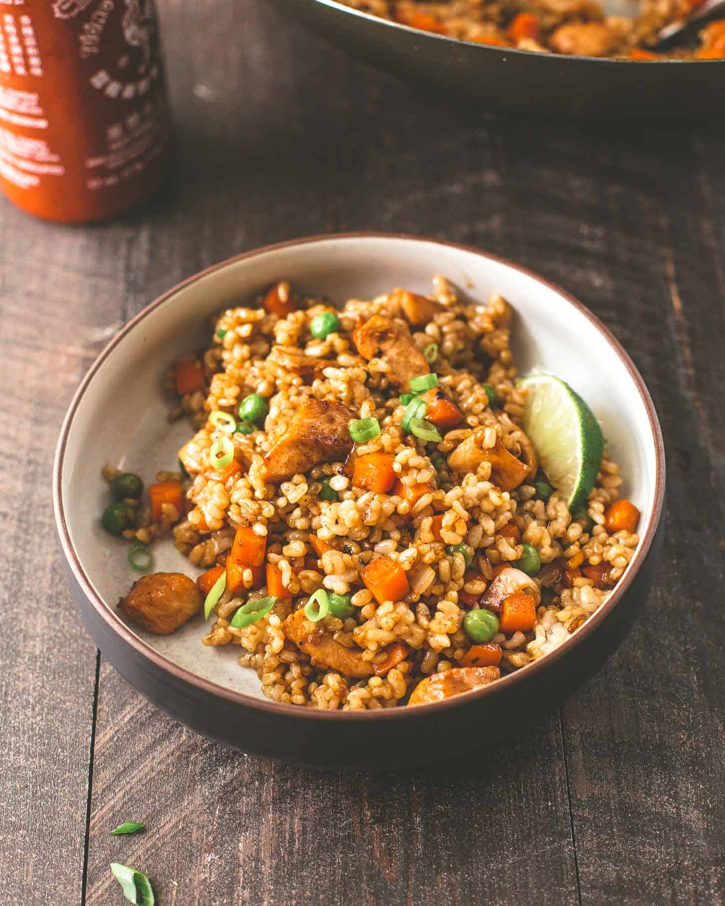 Honey Garlic Chicken Fried Rice in a white bowl on a wood table