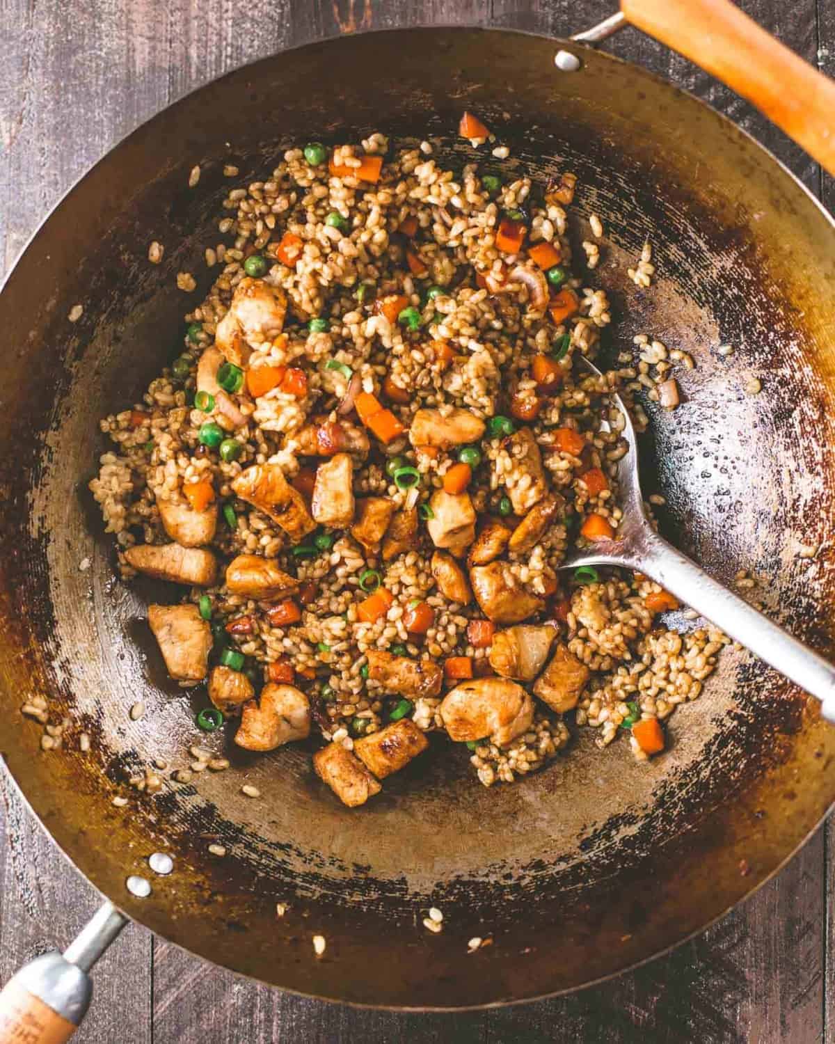 stirring Honey Garlic Chicken Fried Rice in a wok