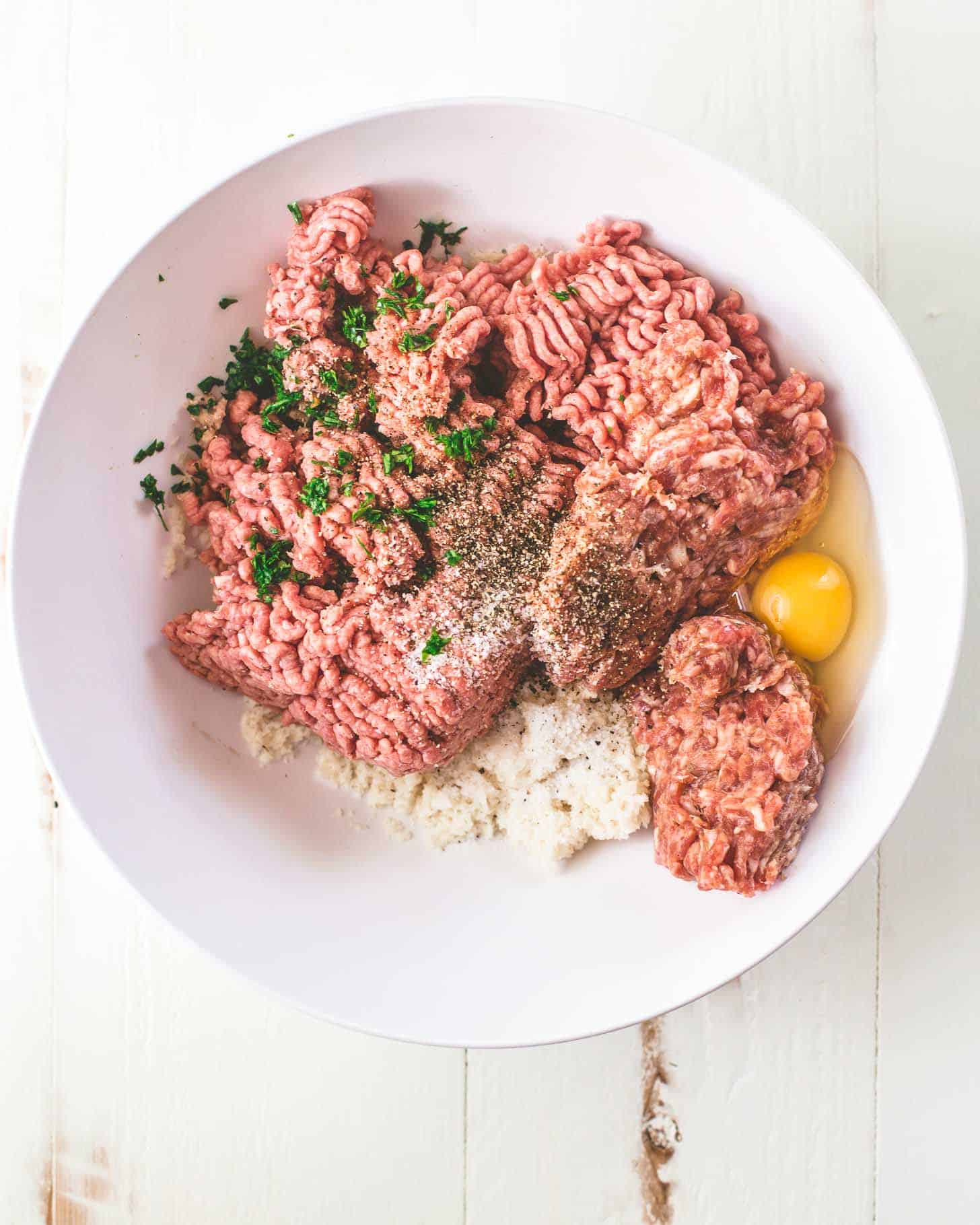 ingredients for meatloaf in a white bowl