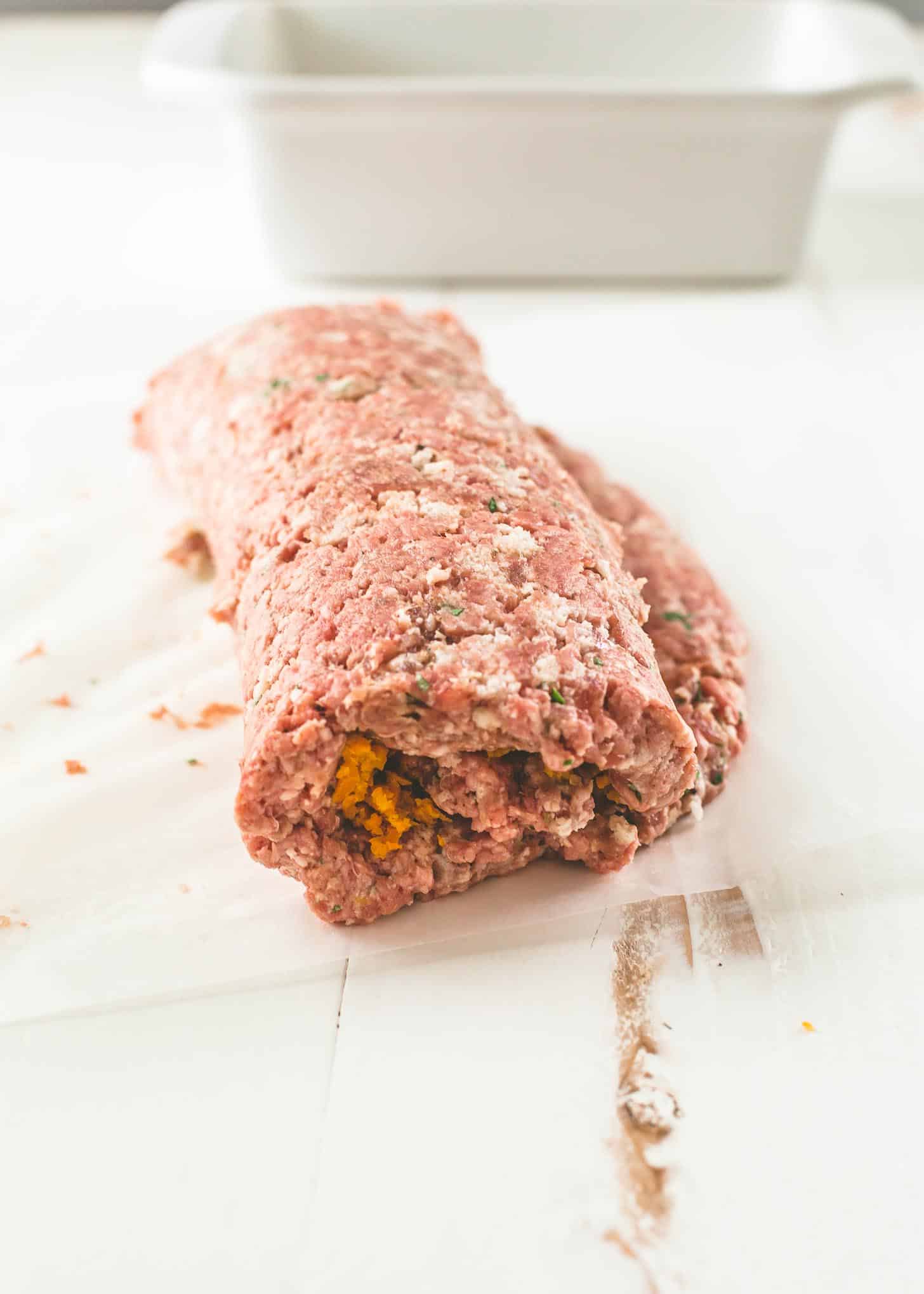 rolling meatloaf on a sheet of parchment paper