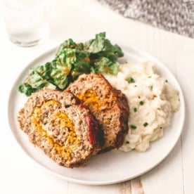 Classic Meatloaf on a white plate with mashed potatoes