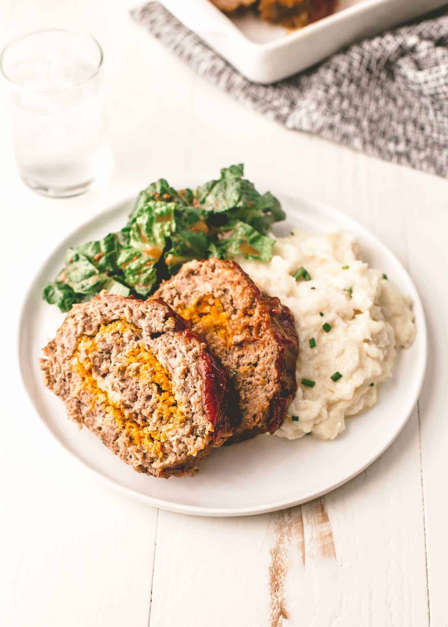 Classic Meatloaf on a white plate with mashed potatoes