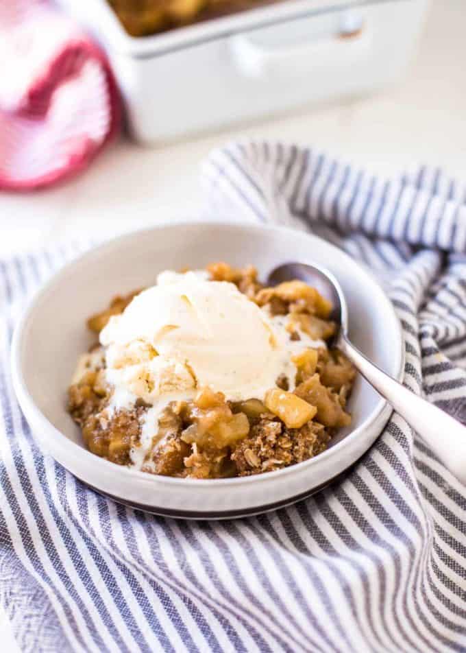 Easy Apple Crumble in a white bowl and topped with vanilla ice cream
