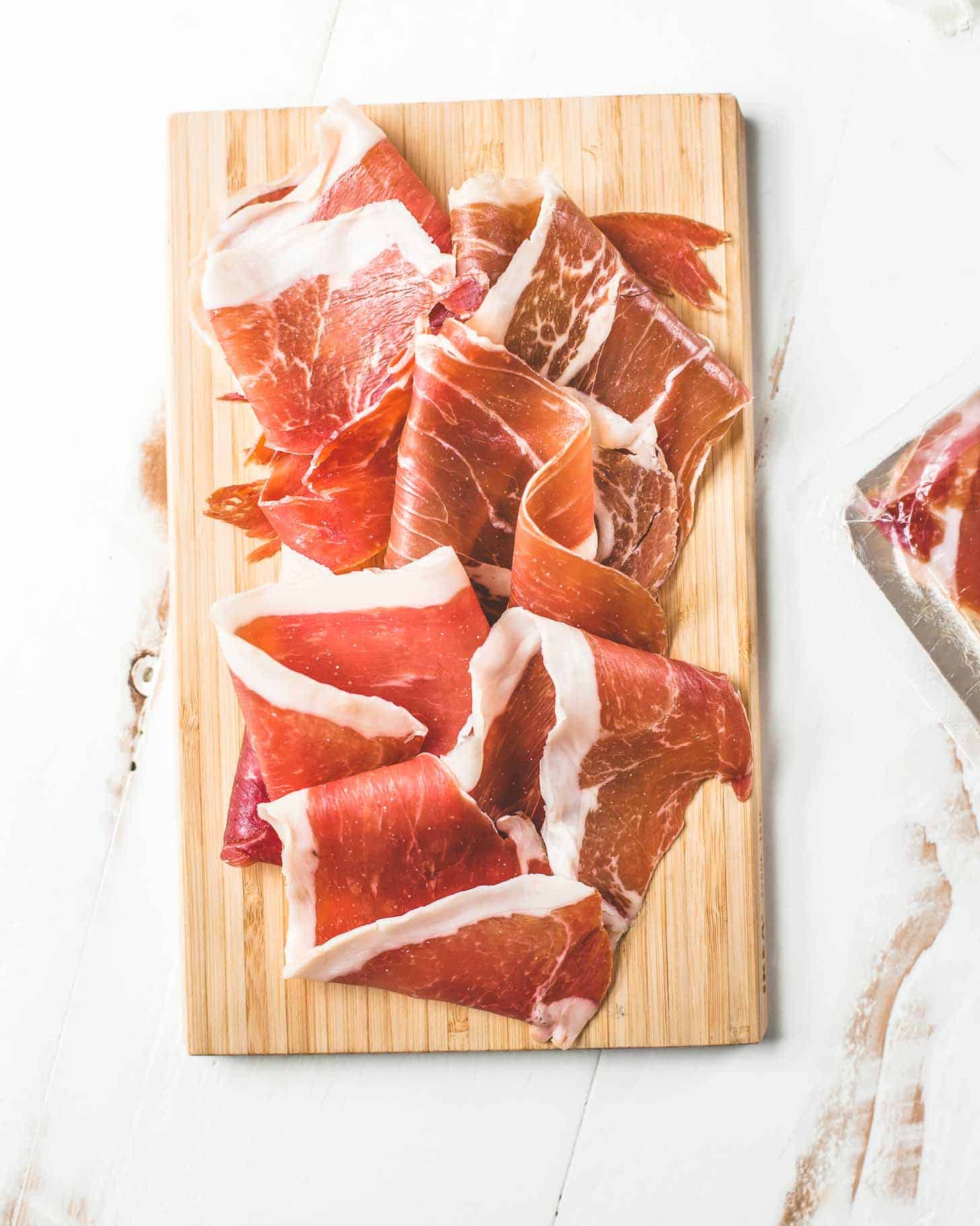 thinly sliced ham on a cutting board