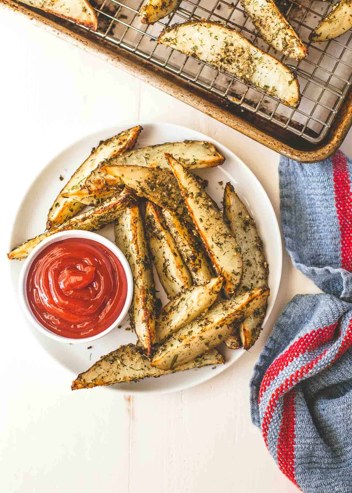 Oven Roasted Ranch Potato Wedges on a white plate with ketchup