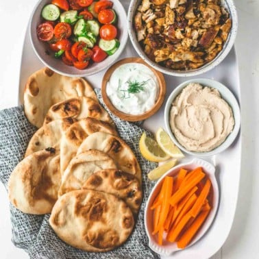 naan, shawarma and toppings on a white tray