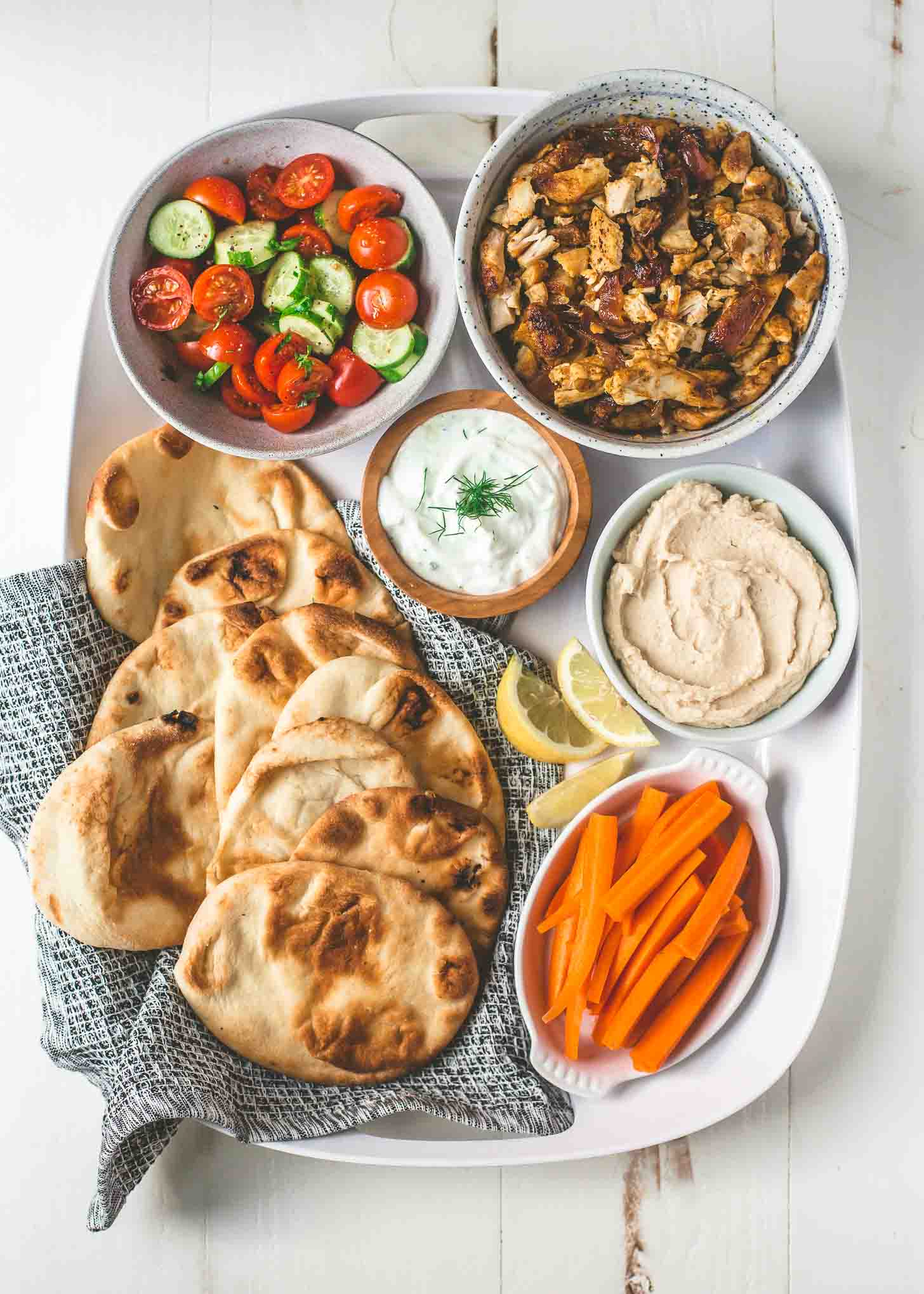 naan, shawarma and toppings on a white tray