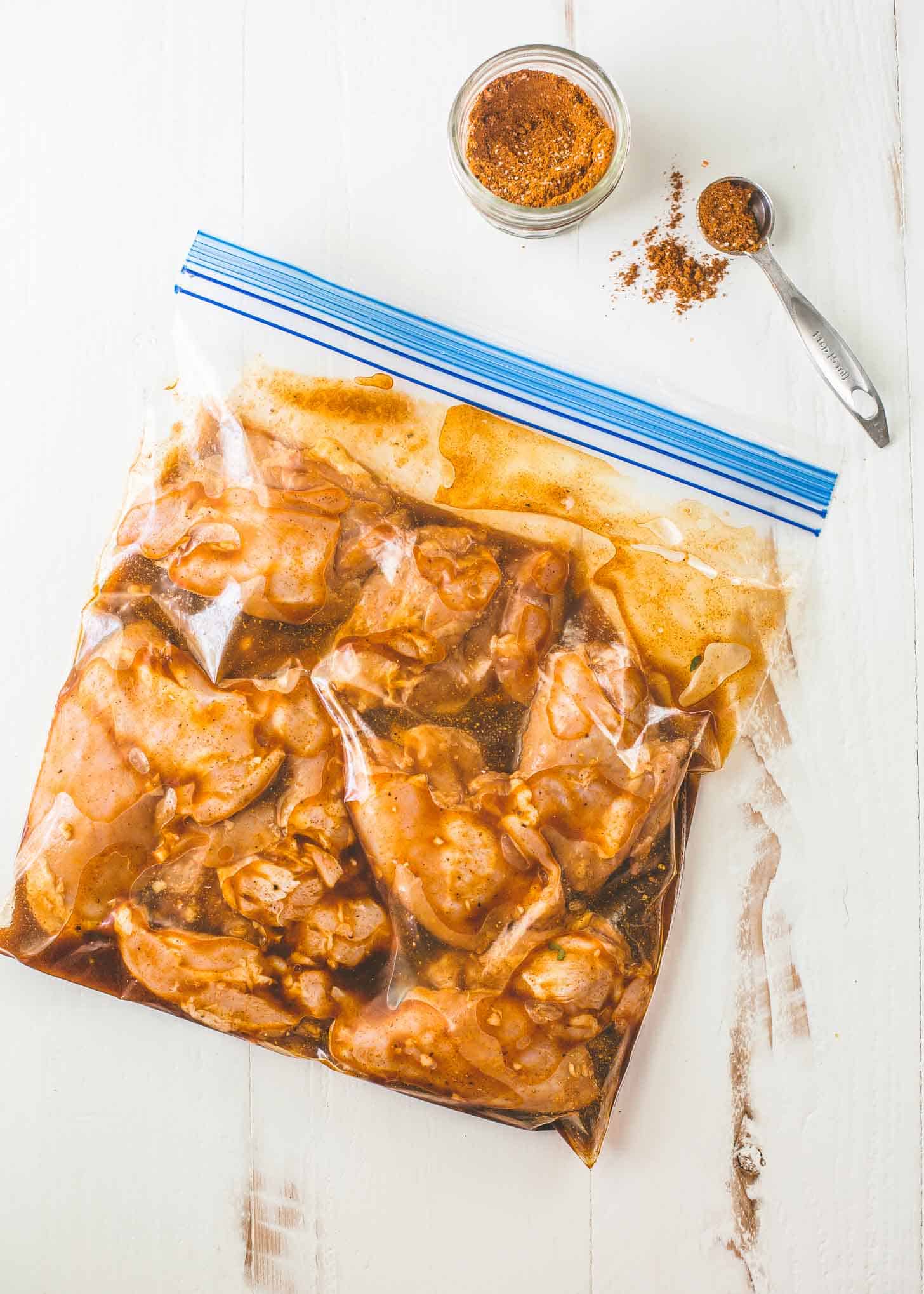 overhead image of marinating chicken in a freezer bag