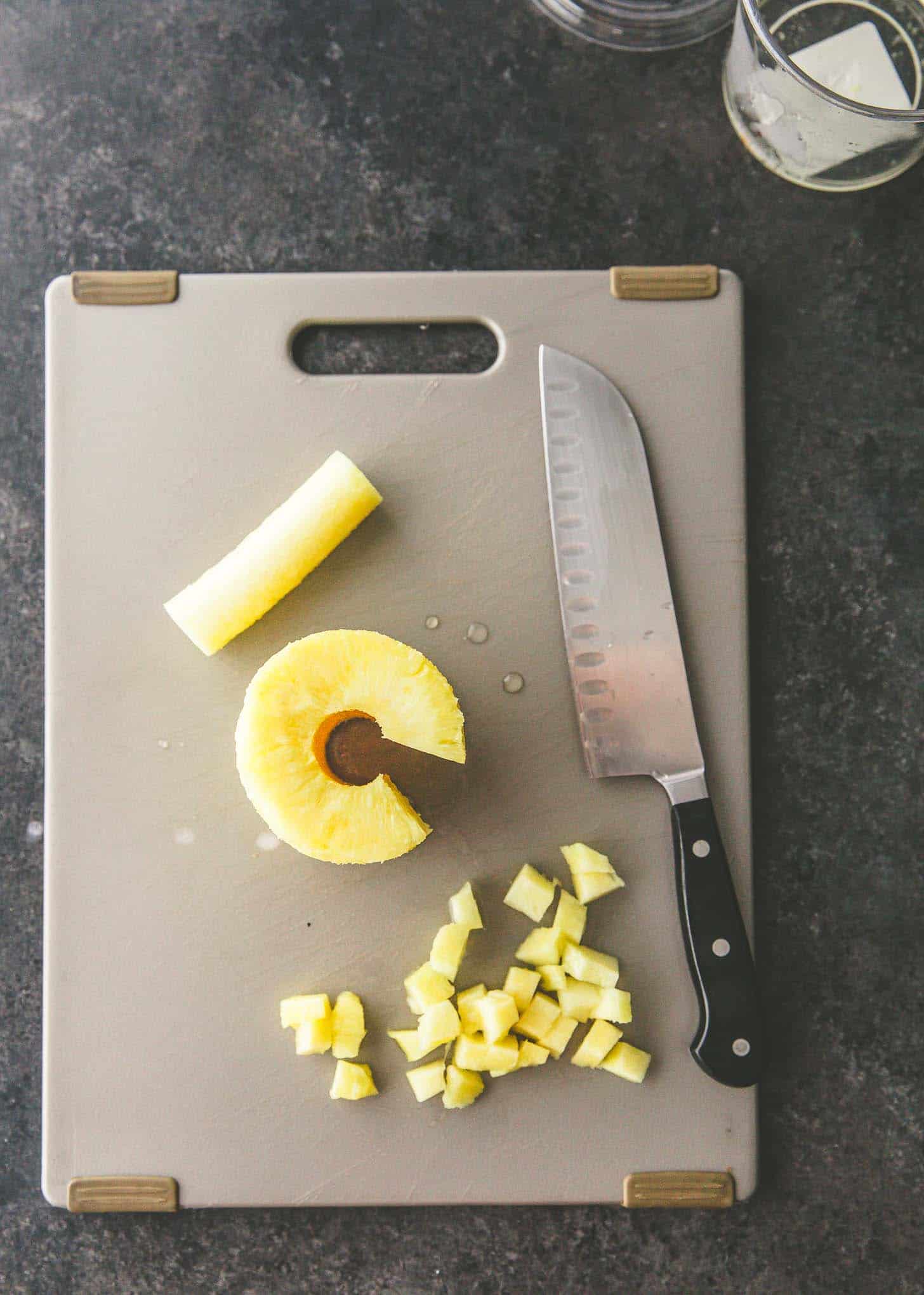 slicing pineapple on a cutting board