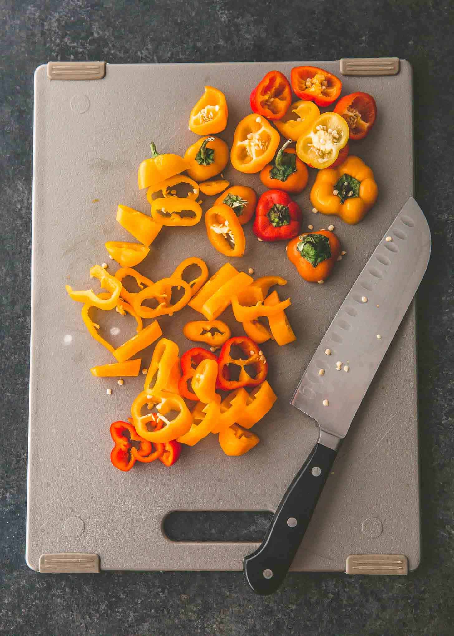 slicing peppers on a cutting board
