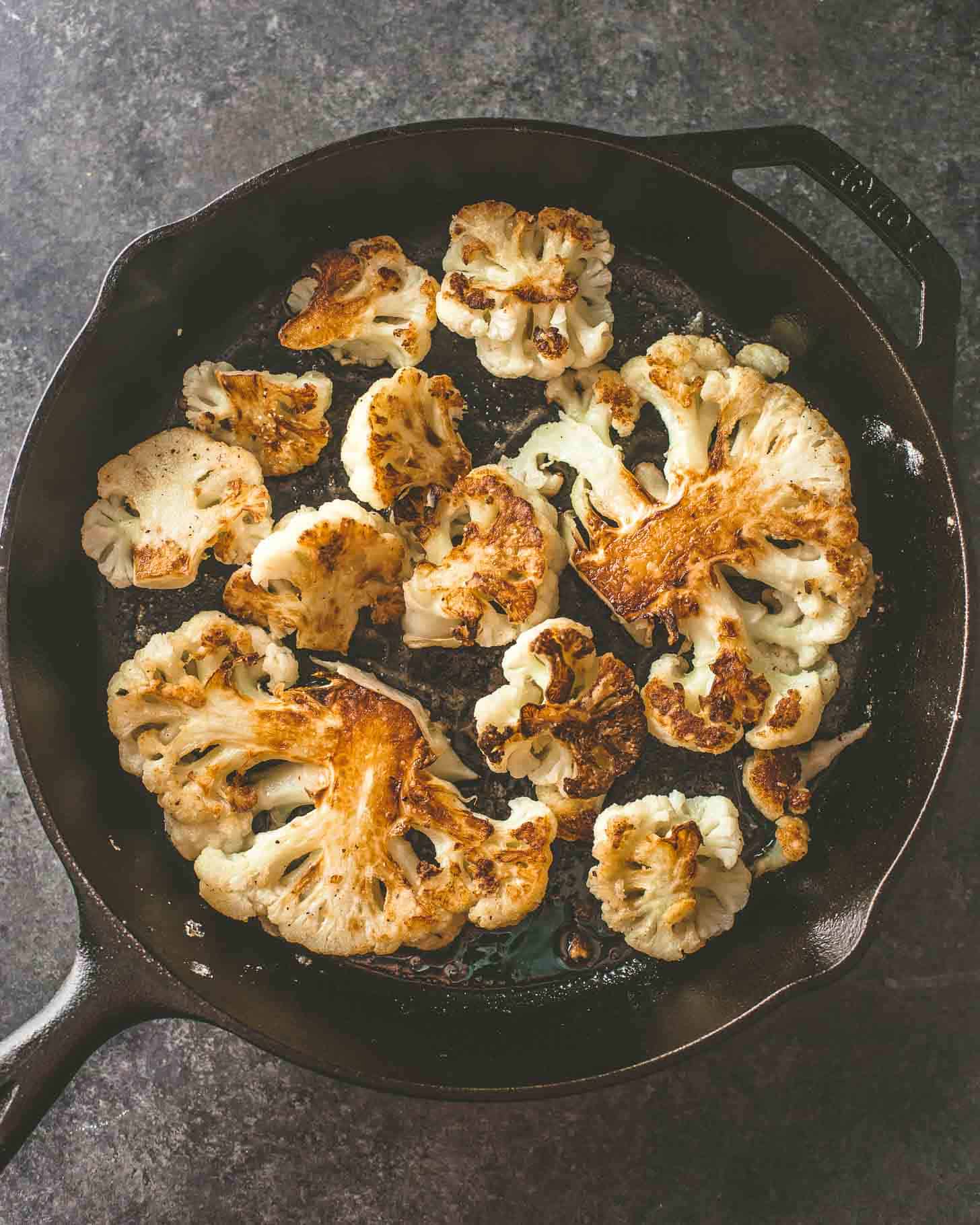overhead image of roasted cauliflower in a skillet