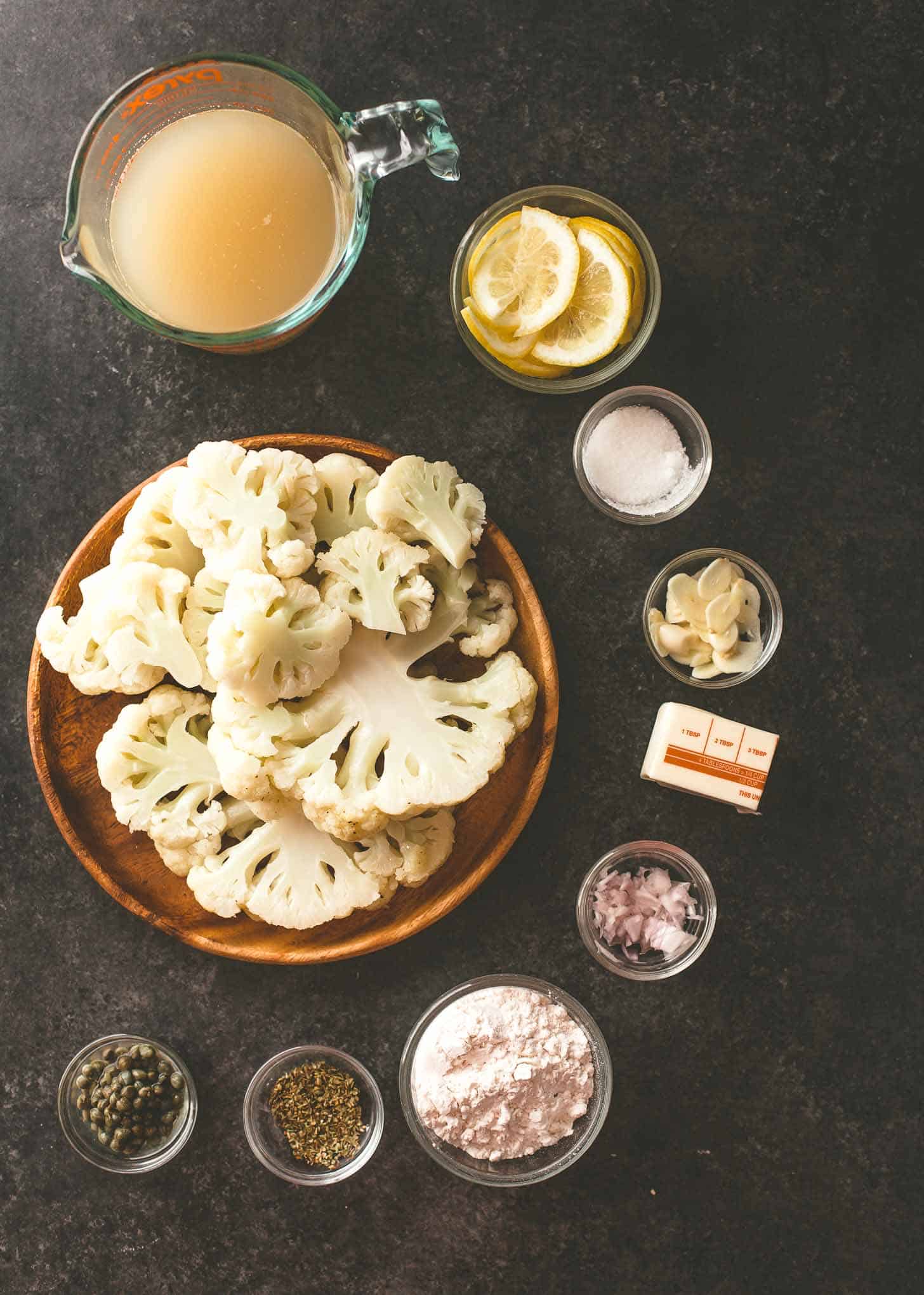 overhead image of ingredients for cauliflower piccata on a grey tabletop