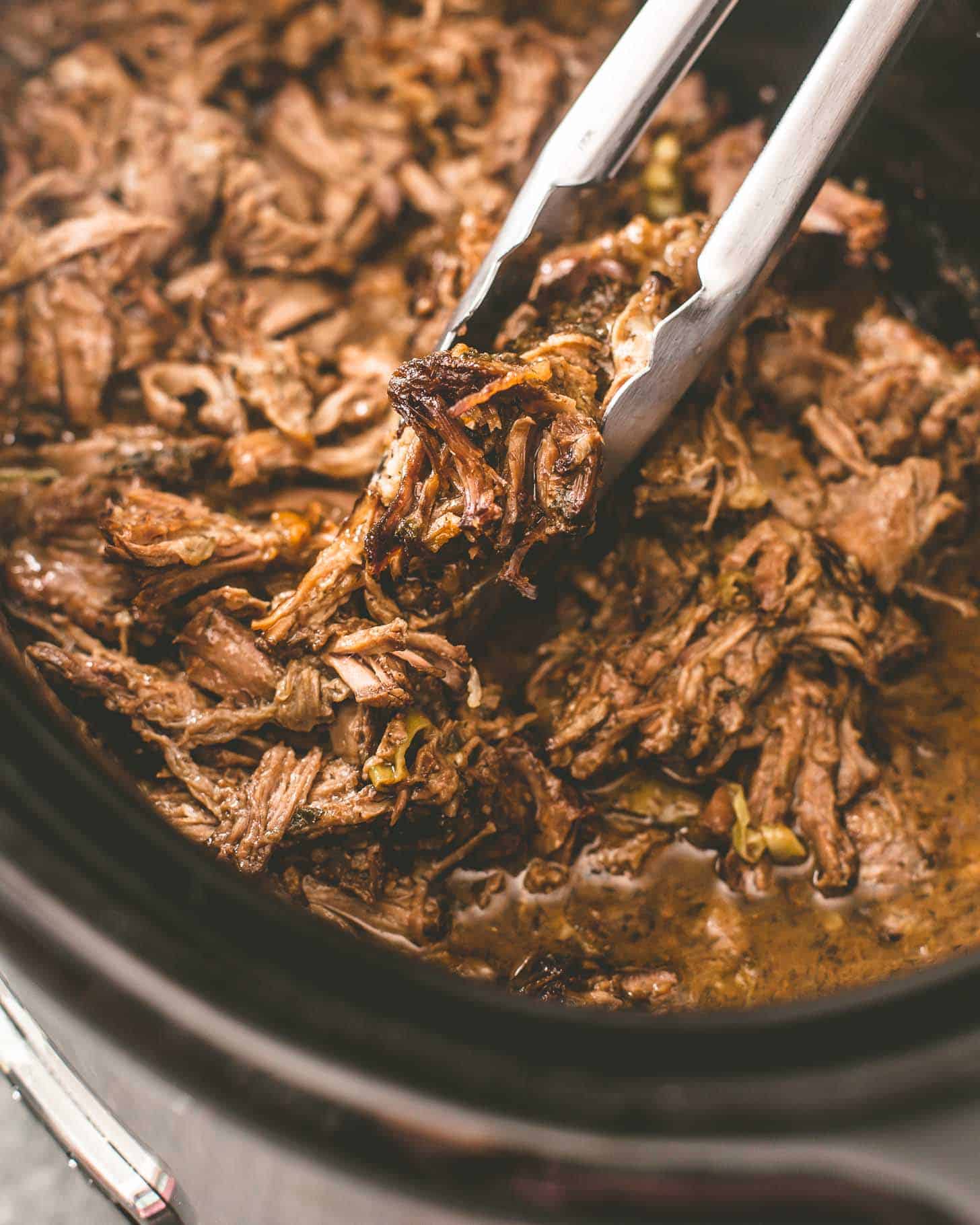 Slow Cooker Mississippi Roast in a slow cooker with tongs