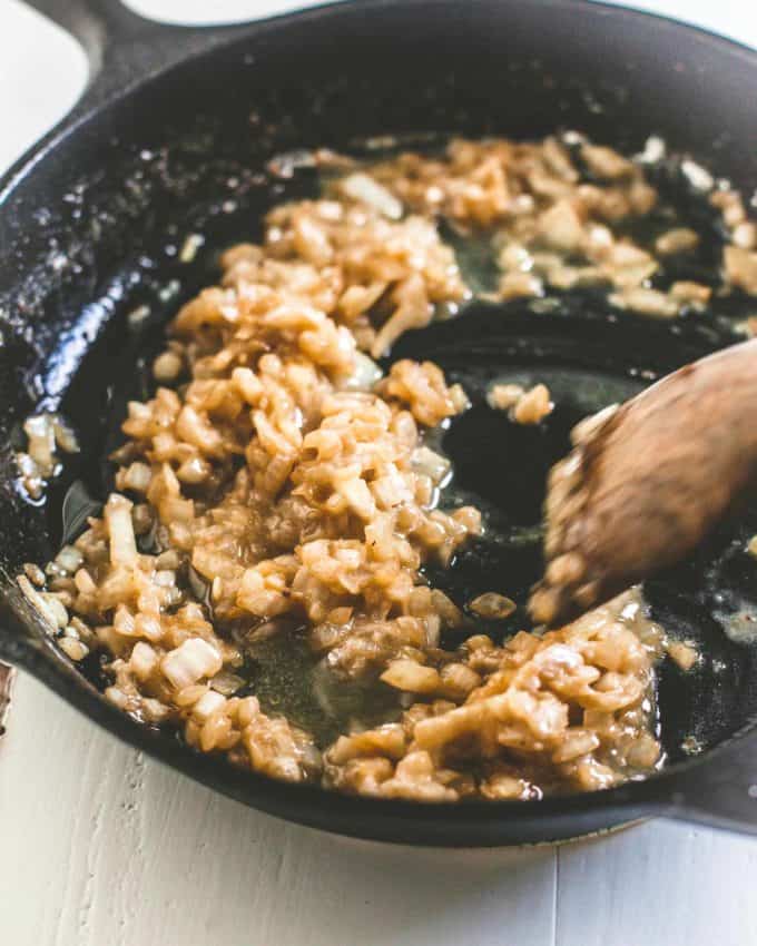 stirring onions in a skillet