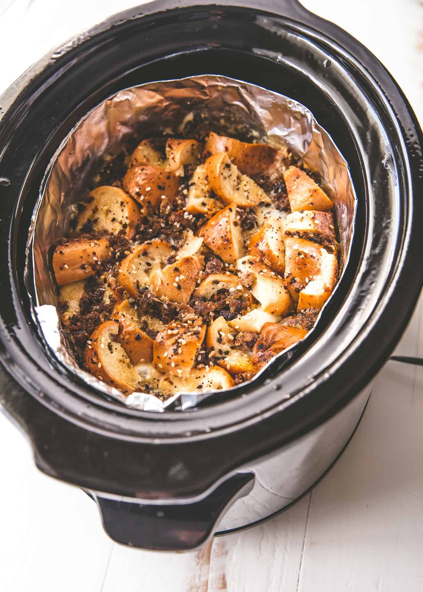 overhead image of bagels and spices in a foil lined slow cooker