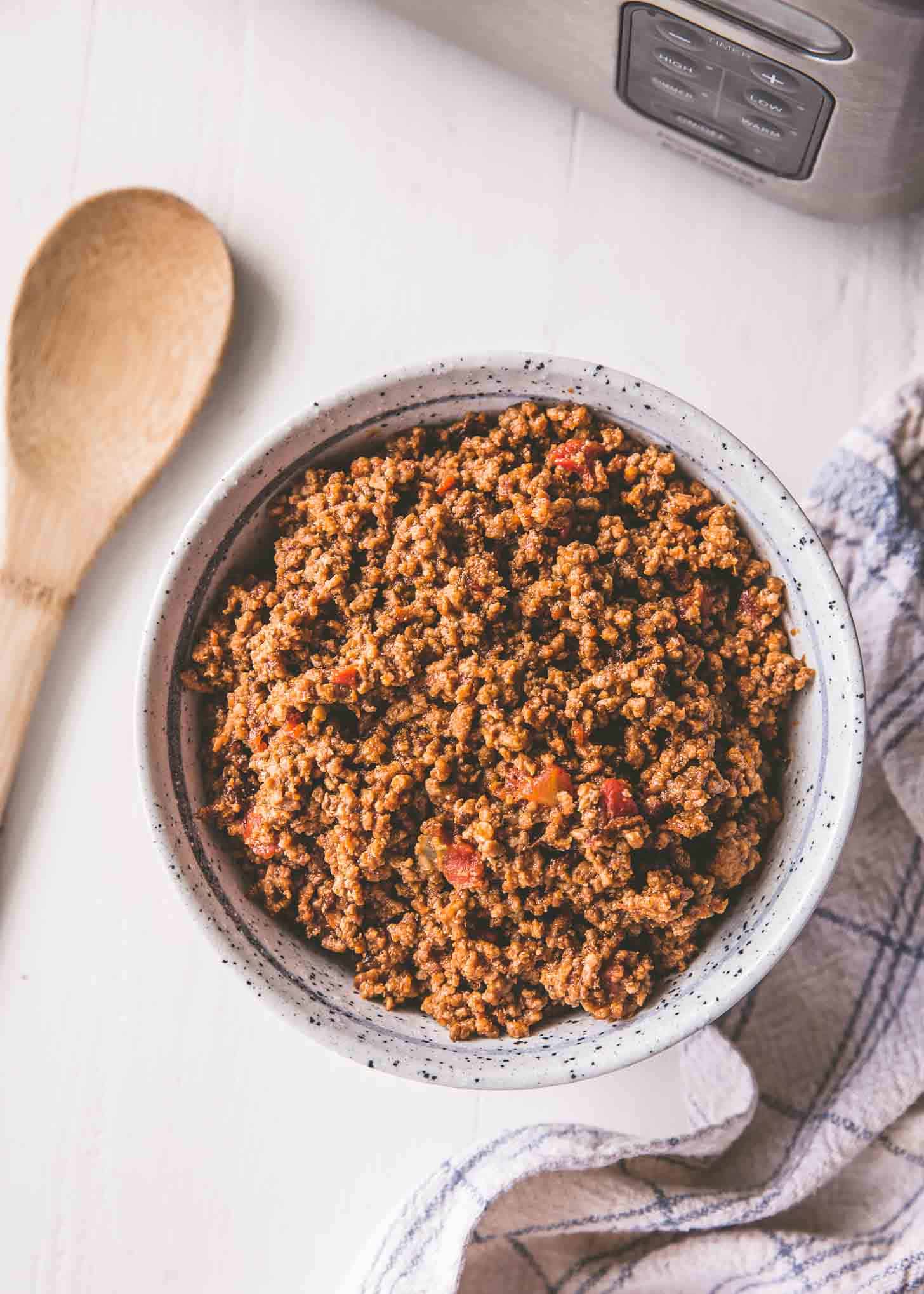 overhead image of slow cooker taco meat in a white bowl