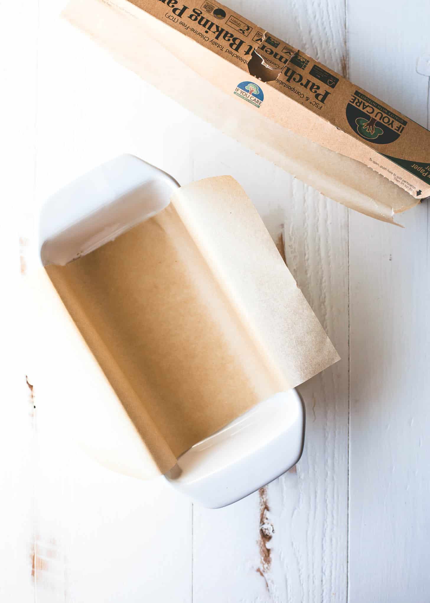 overhead image of a white loaf pan lined with parchment paper