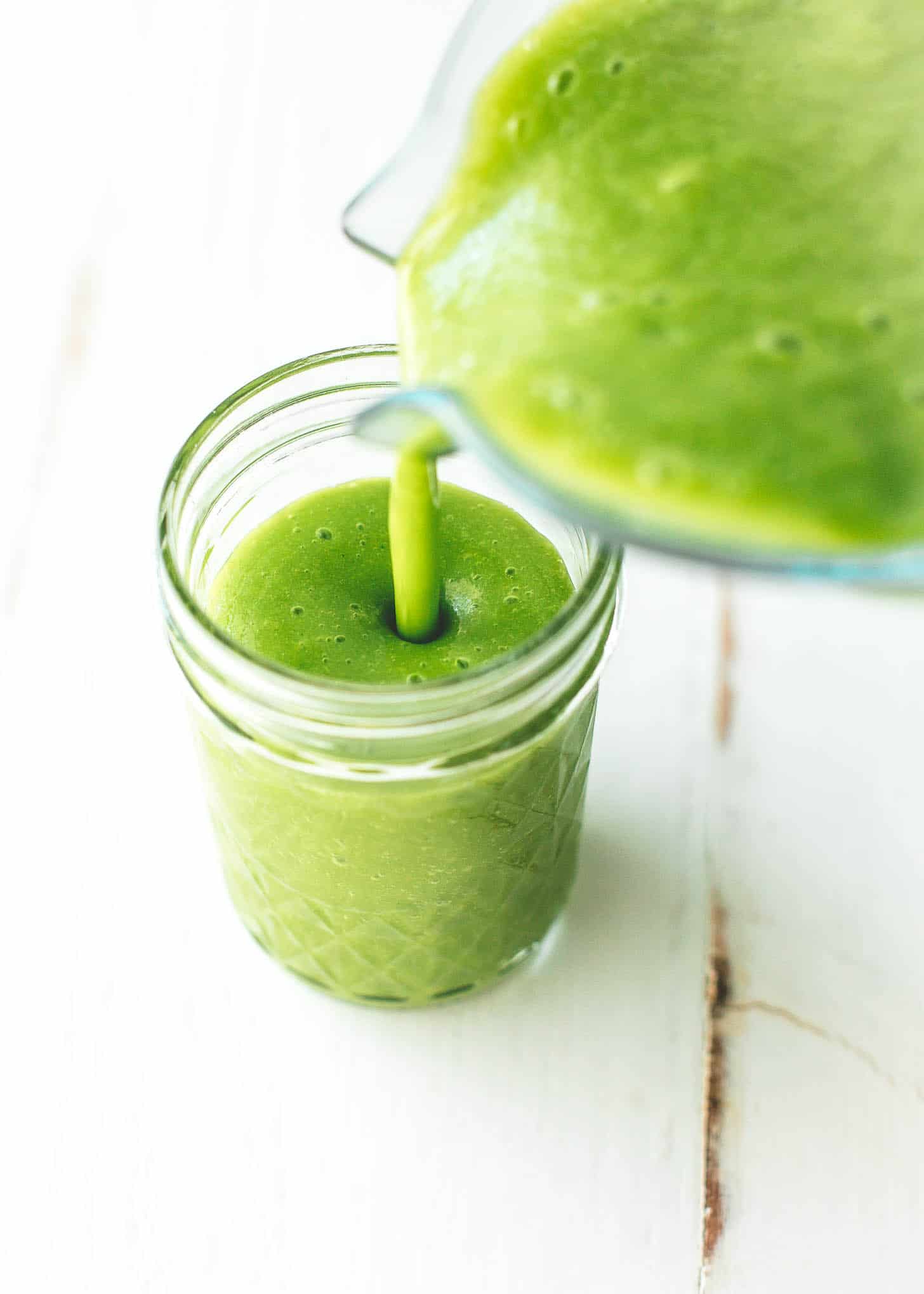 Pouring Green Smoothie into a glass jar