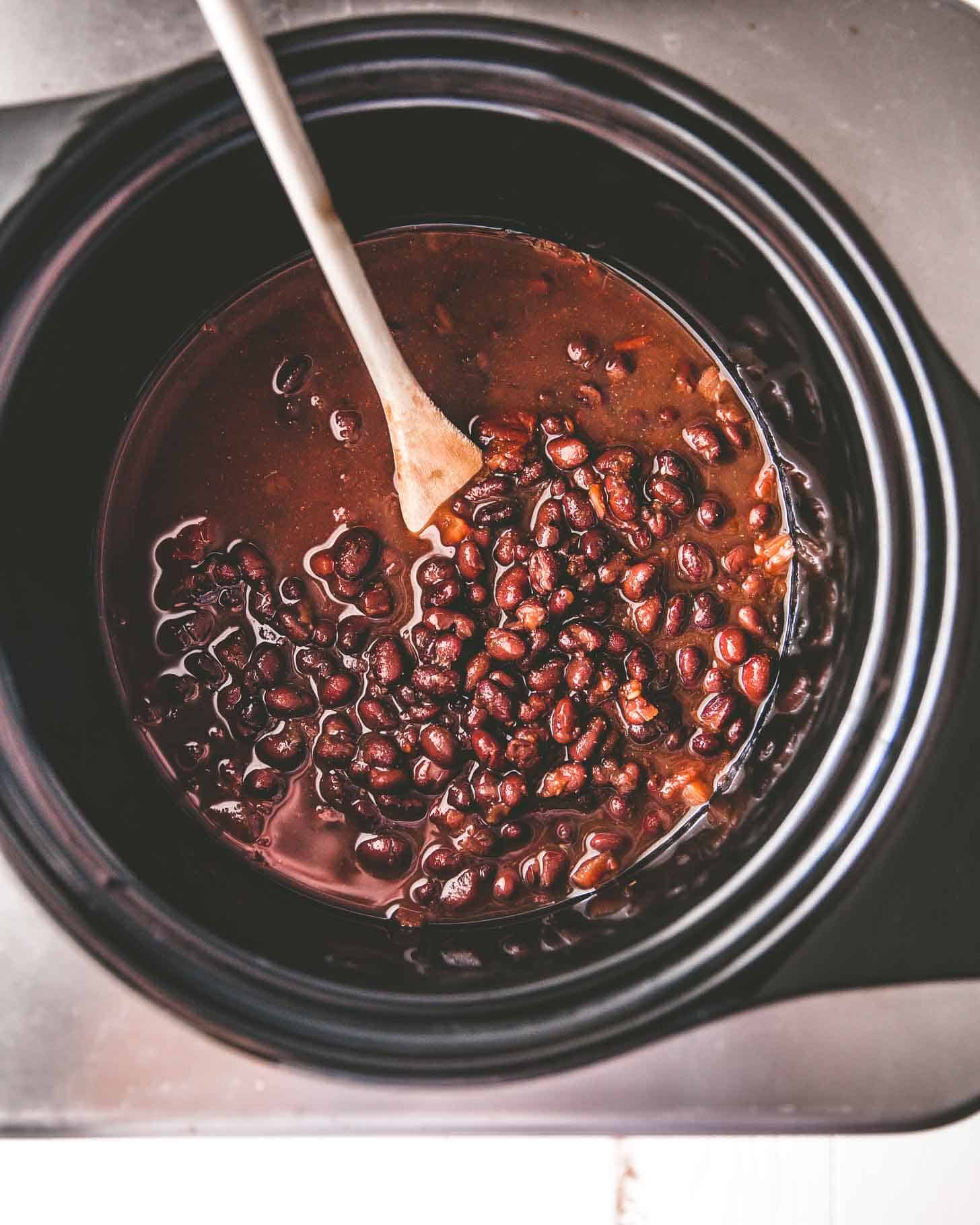 overhead image of black beans in a slow cooker