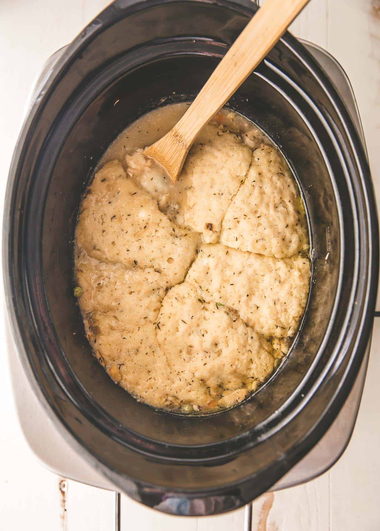 overhead image of chicken and biscuits in a slow cooker