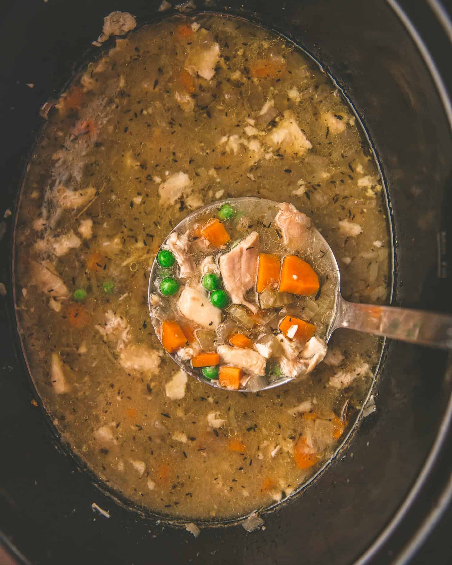 overhead image of chicken soup in a slow cooker with vegetables