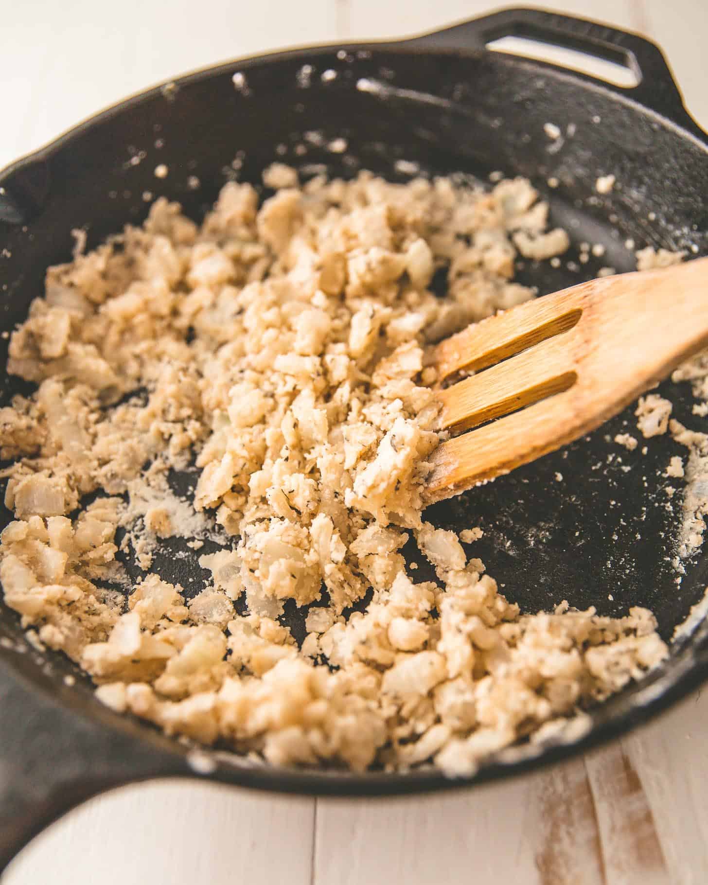 stirring flour and onions in a cast iron skillet