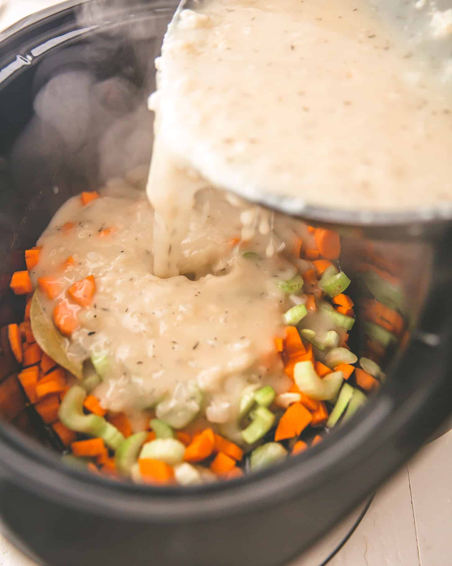 adding flour mixture to vegetables in a slow cooker