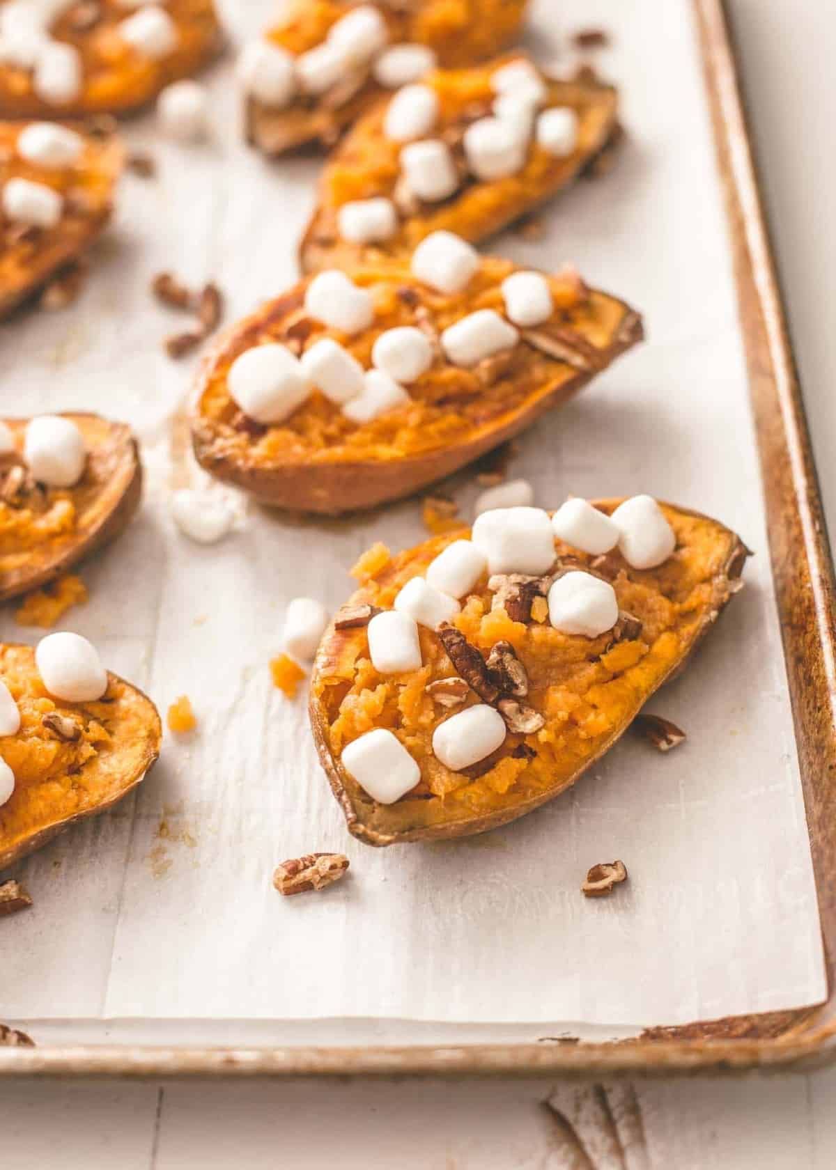twice baked sweet potatoes on a parchment lined sheet pan