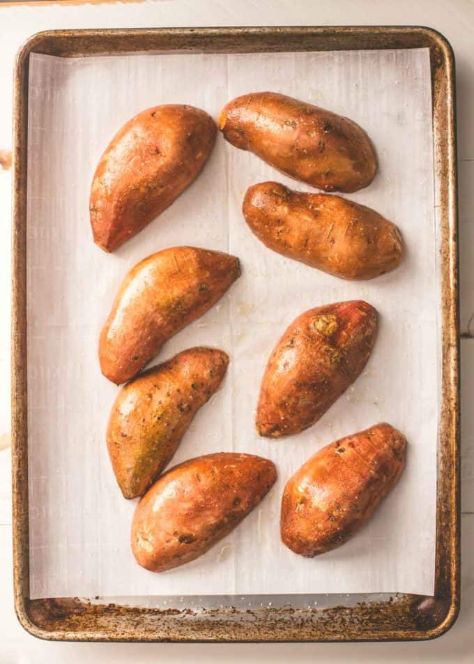 sweet potatoes on a parchment lined sheet pan